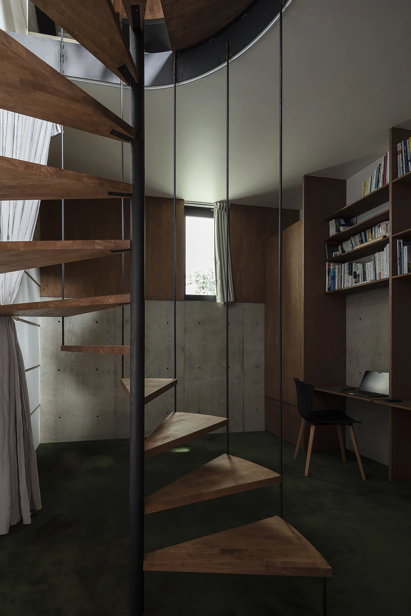 House in Kagurazaka by Takumi Wakui + Riho Wakui Architects — Timber treads wind down past the central double wall to a study niche lit by a single framed window.