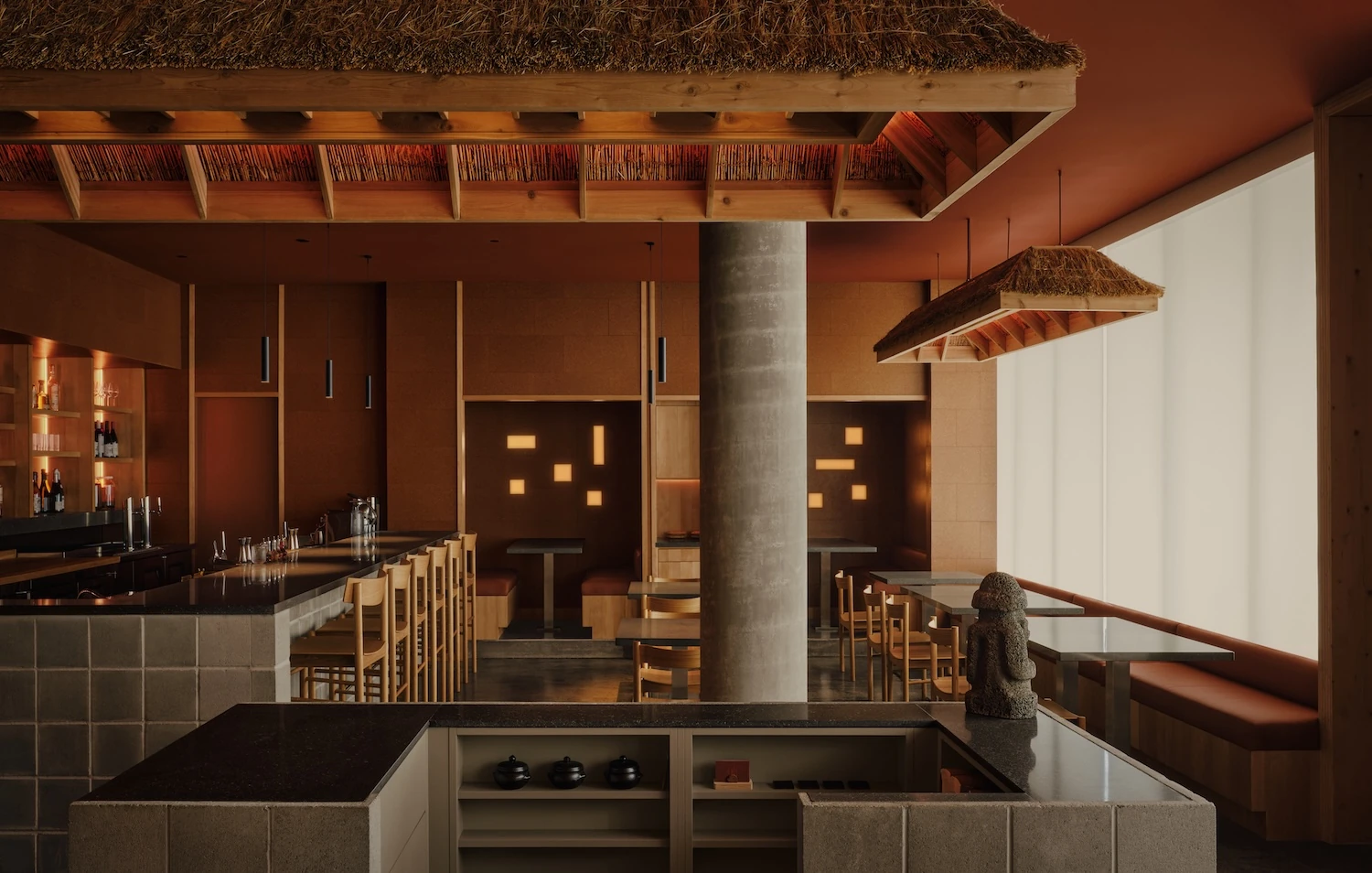 Jeju by &Daughters, photographed by Alex Lesage — A dining table against a timber partition, a sideboard set with glassware behind and a mirrored strip above.