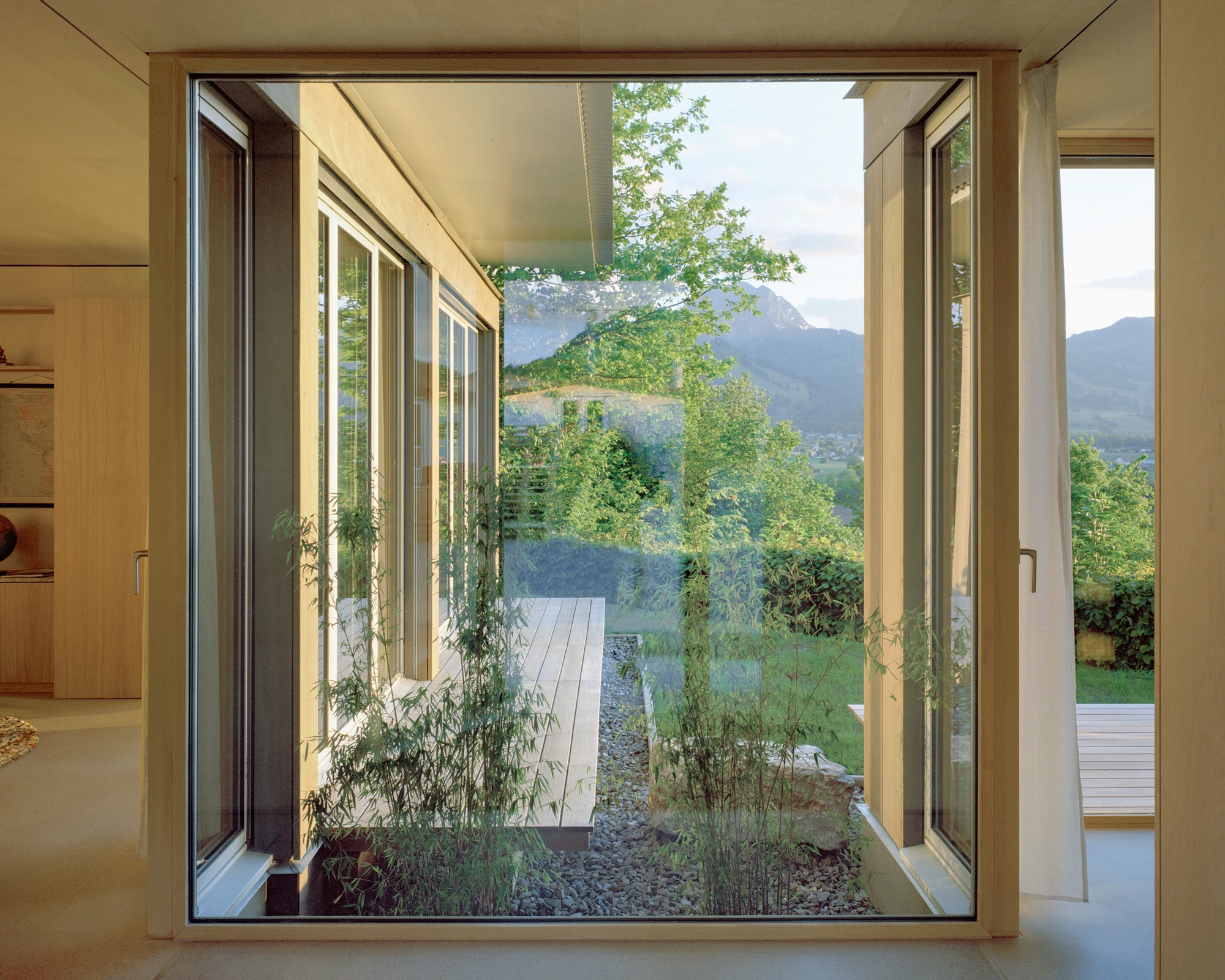 Plywood House by Charly Jolliet Architecte, photographed by Maxime Delvaux — Plywood covers walls and ceiling, with a table in a different wood species set against the lining.
