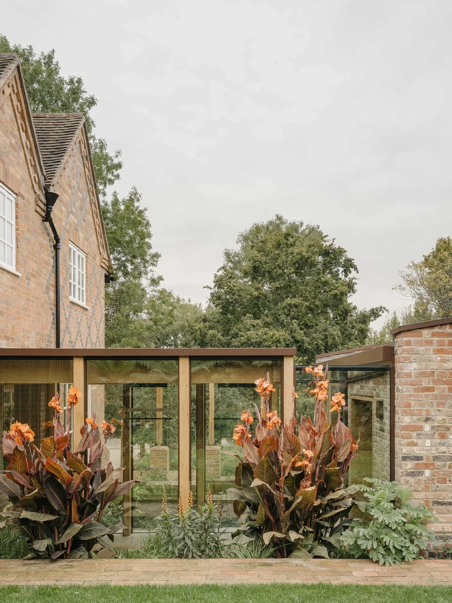 Muttram Veedu by Will Gamble Architects, photographed by James Retief — The timber glazed link joins the cottage to the new brick volume across a planted courtyard.