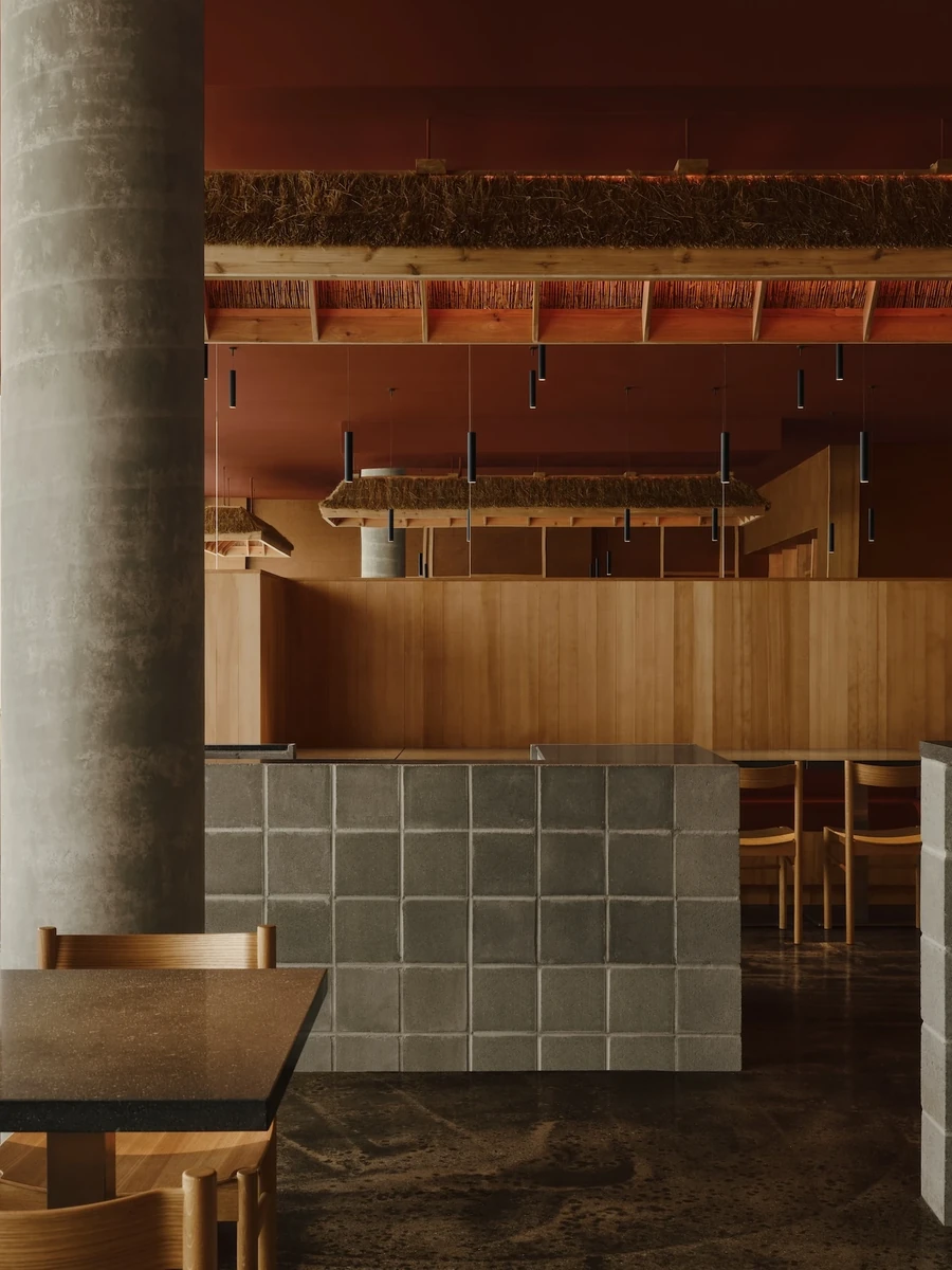Jeju by &Daughters, photographed by Alex Lesage — The jeongnang, Jeju Island's three-pole gate, set within the timber-framed entry glazing as the restaurant's open-and-closed sign.