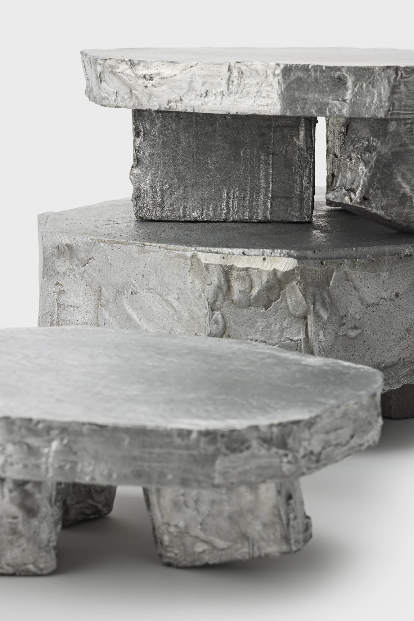 Lying on the floor by StudioFA, photographed by Yongin Myoung — Two stacked pieces behind a third form in the foreground, its three legs clear of the floor.
