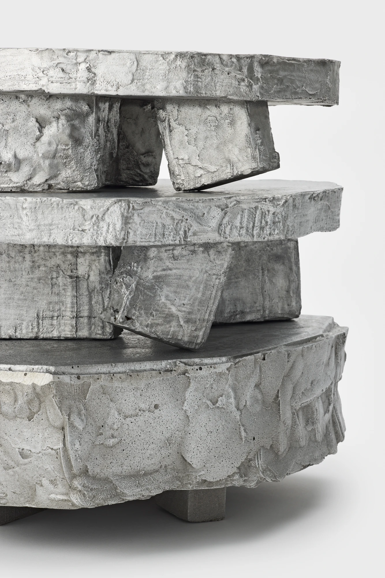 Lying on the floor by StudioFA, photographed by Yongin Myoung — A tight view of the stack, one leg tilted against the slab beneath it.
