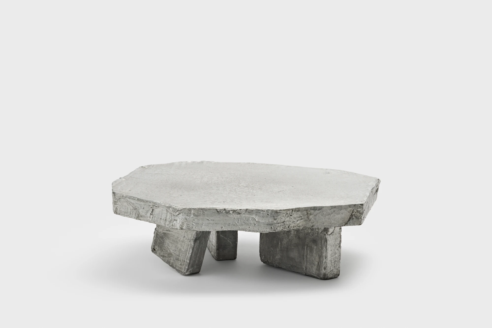 Lying on the floor by StudioFA, photographed by Yongin Myoung — Another of the pieces from the side, three legs set wide beneath an irregular faceted slab.