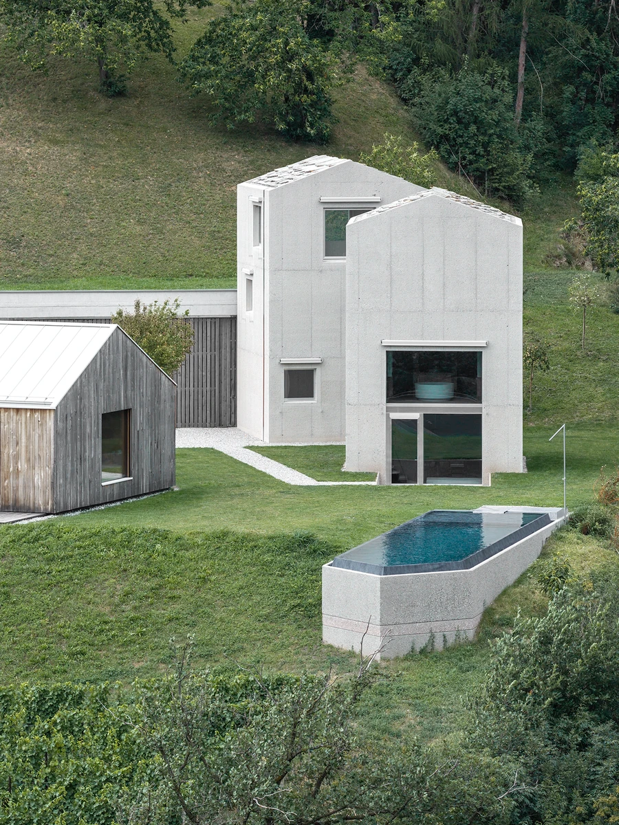 Val Mira by Andreas Gruber Architects — Ritten, Italy: raw concrete towers with wood-lined rooms, a brass kitchen and a hill-cut pool