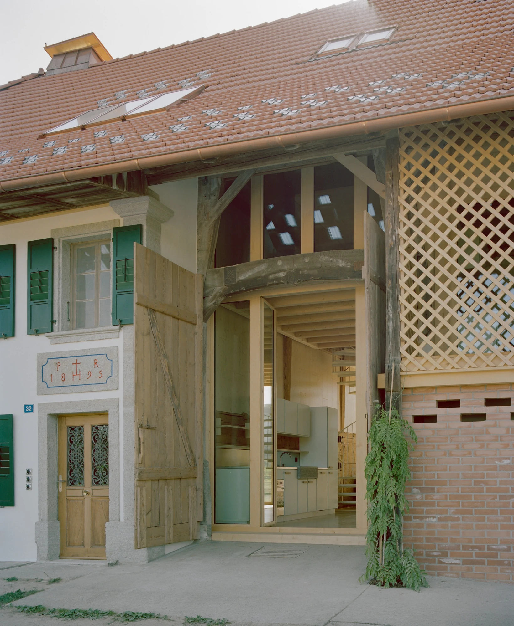 Conversion of a Farmhouse into Six Apartments by Noue Studio, photographed by Willem Pab — A tall glazed opening slotted into the old timber frame beside the dwelling’s front door.
