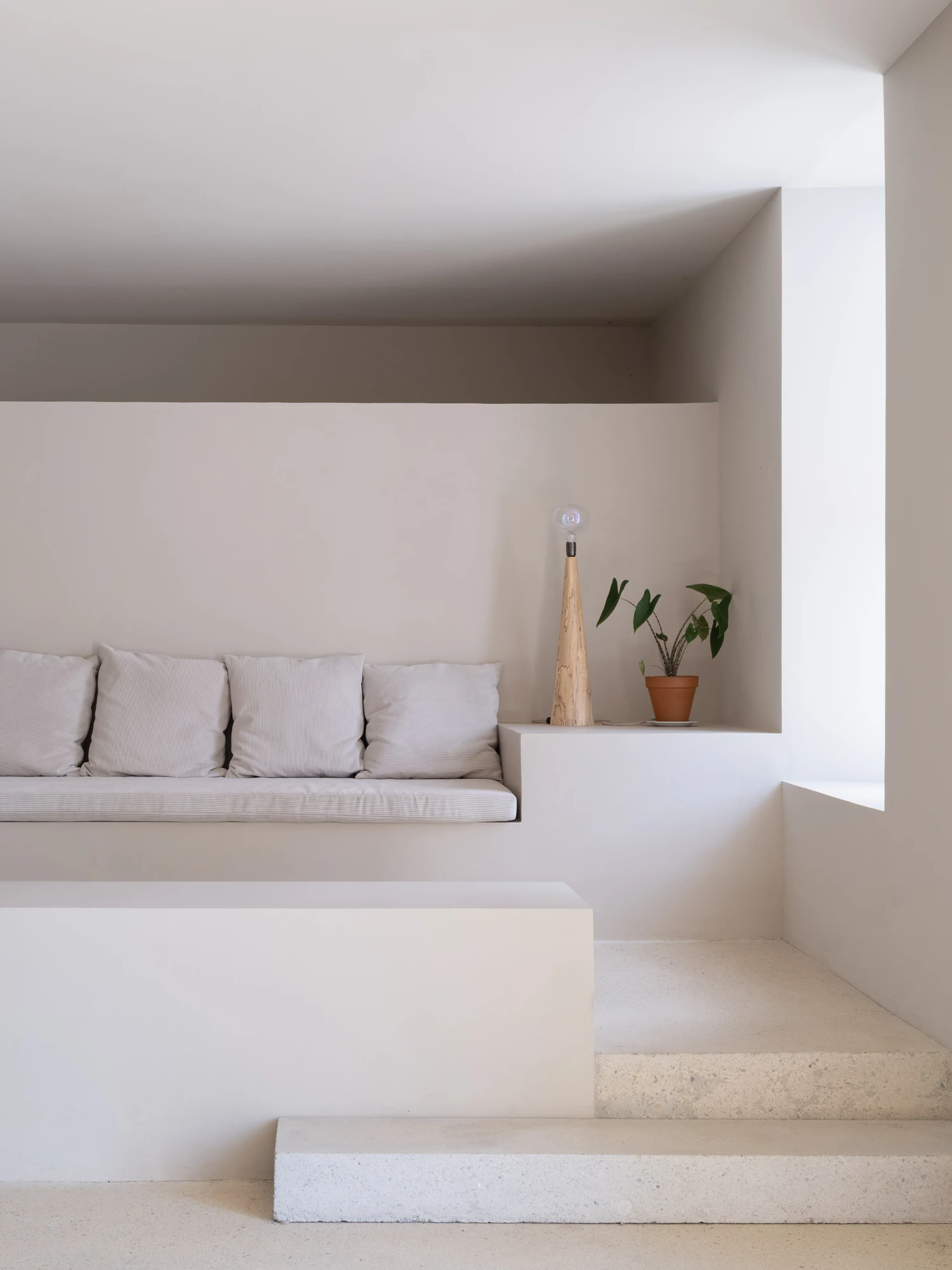 Farmhouse Renovation by Atelier AJO, photographed by Sandrine Iratçabal — A built-in bench set into a niche beside steps that drop to a lower level.