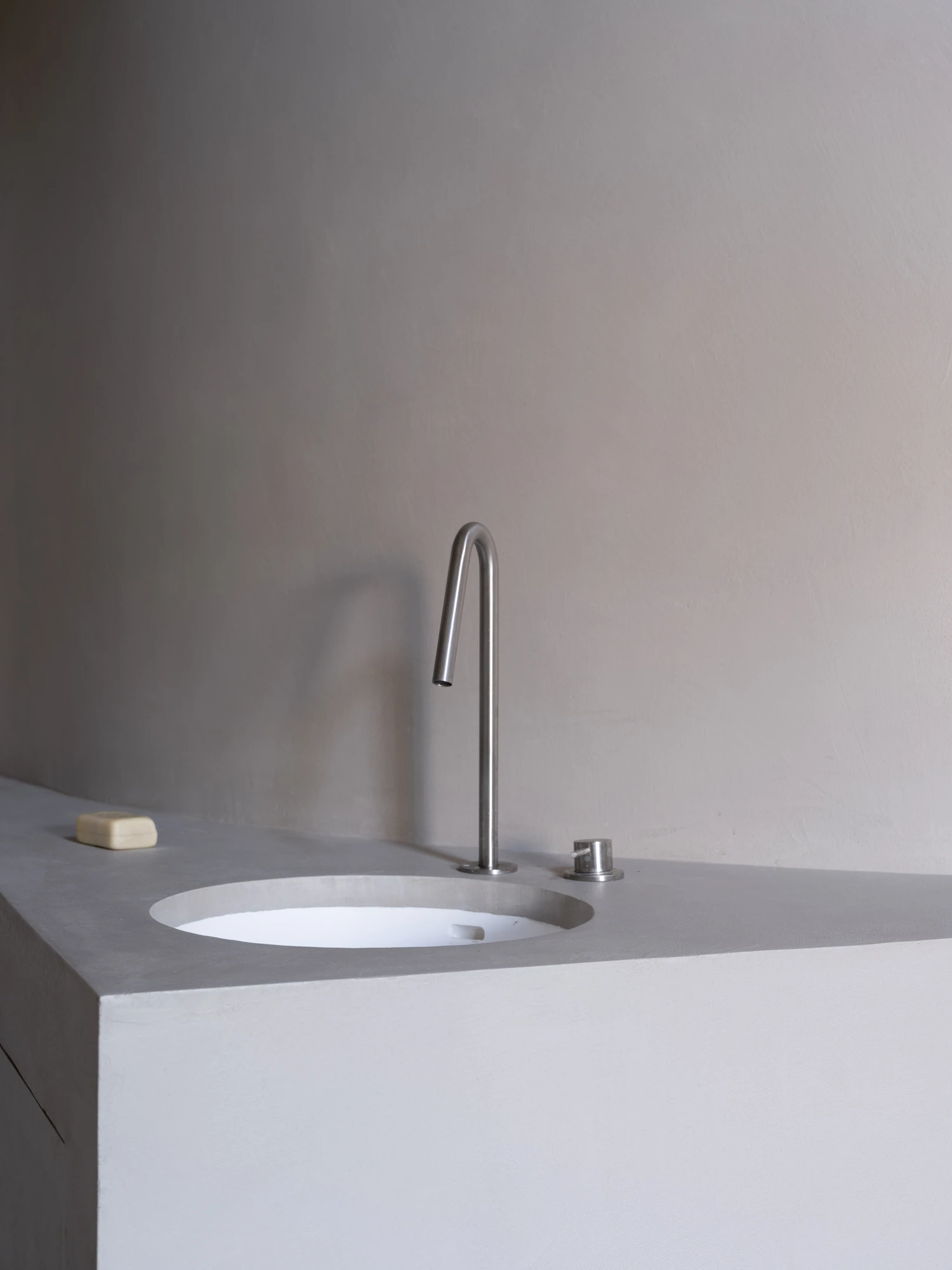Farmhouse Renovation by Atelier AJO, photographed by Sandrine Iratçabal — A basin set into a rendered block beneath a tall slender tap.