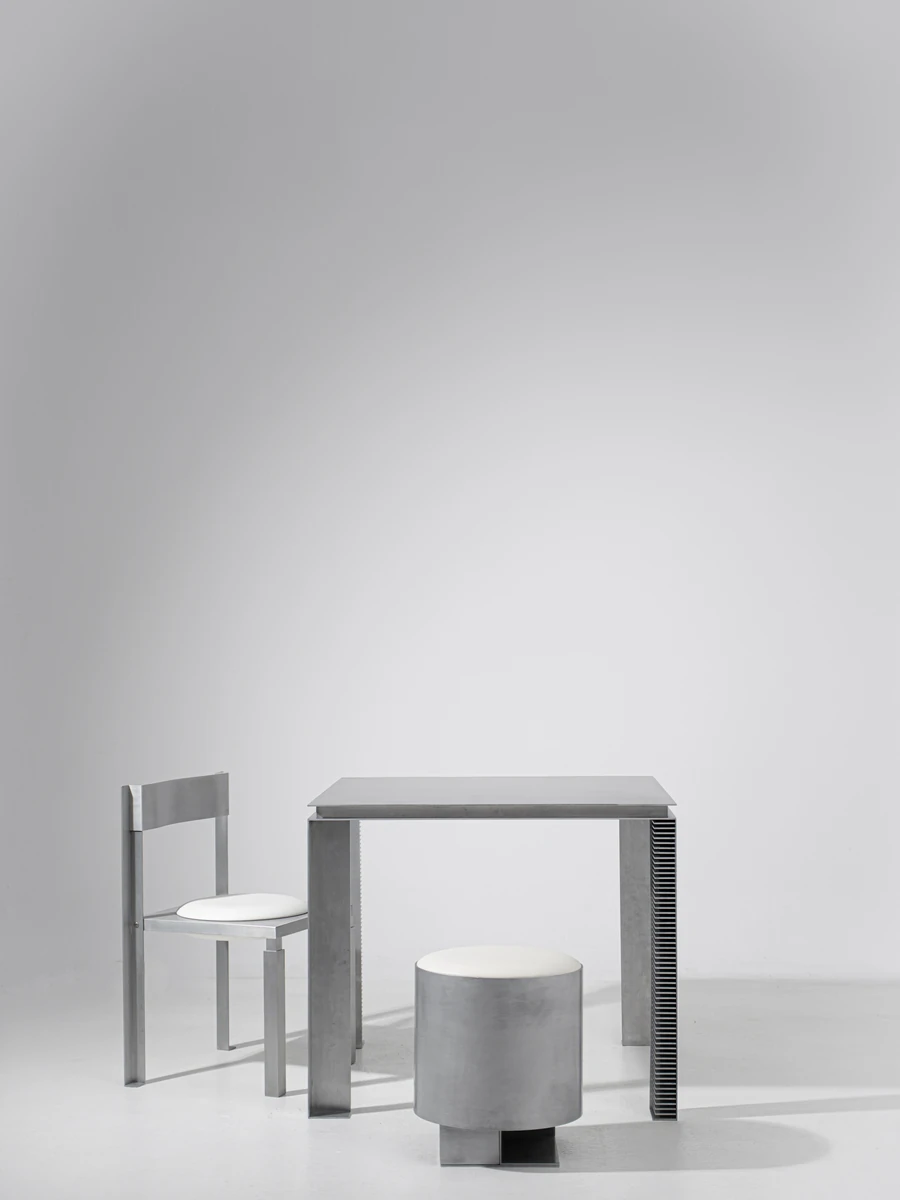 Strut Collection by YET. Design Studio, photographed by Kaan Bayoglu — The three Strut pieces grouped in a vertical studio frame, chair at left, table centre, pouf set in front.