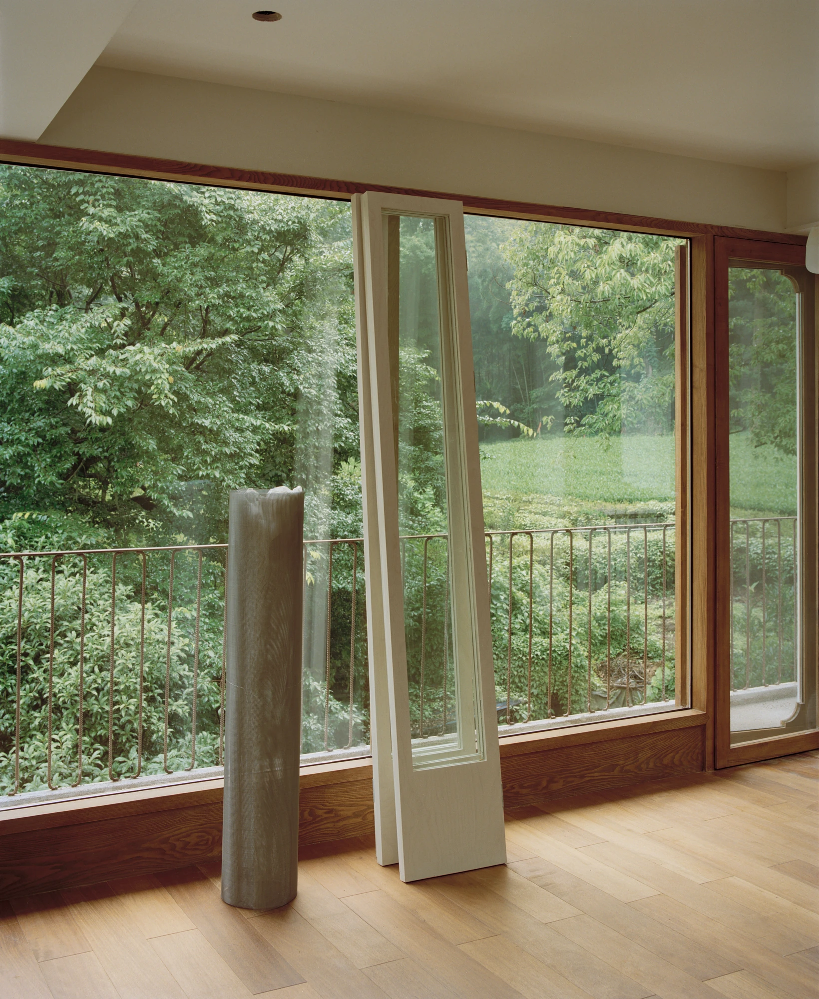 L Hermit House II by Common Wonder, photographed by Willem Pab, Eva Candela — Large glazed openings framing the surrounding woodland.