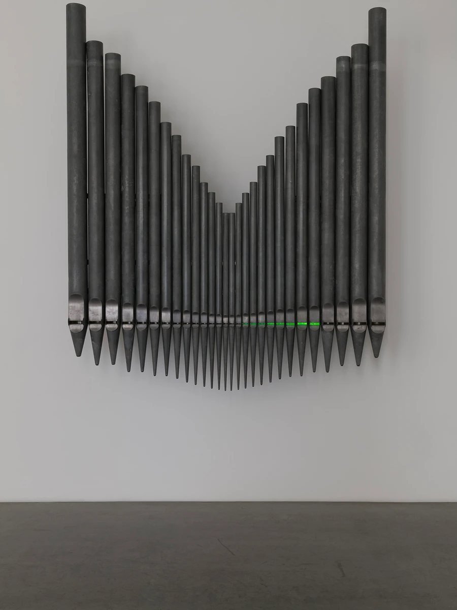 Half-Life of Grace by Jeremy Shaw, photographed by Stefan Korte — A vertical crop of the same organ-pipe sculpture, the neon green glow concentrated along the row of pipe mouths.