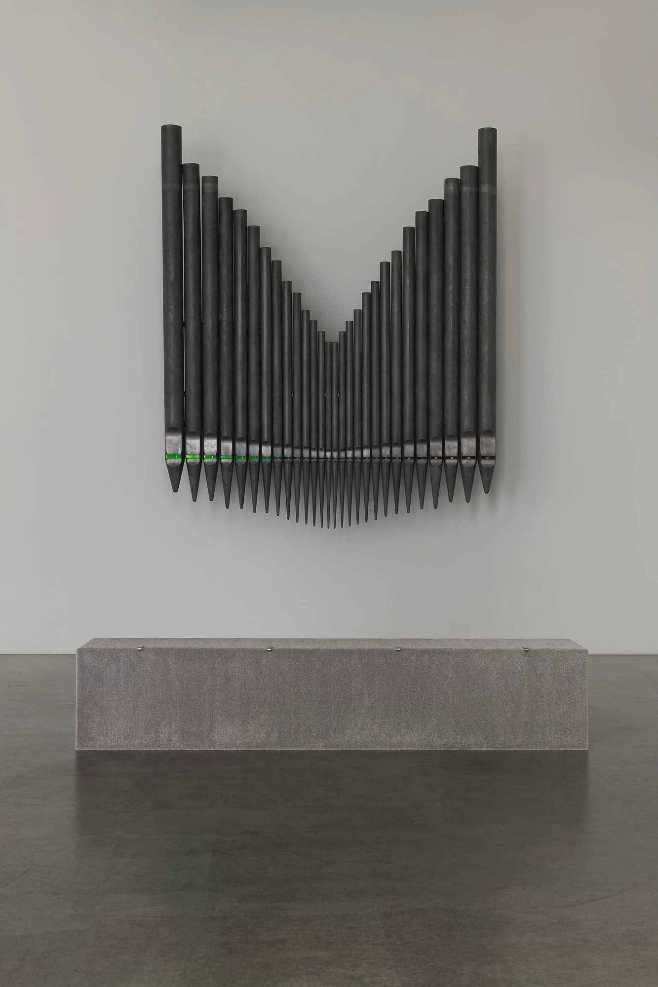 Half-Life of Grace by Jeremy Shaw, photographed by Stefan Korte — Half-Life of Grace (1958) seen frontally on the second-room wall, its 28 pipes tapering to points beneath a band of green light.
