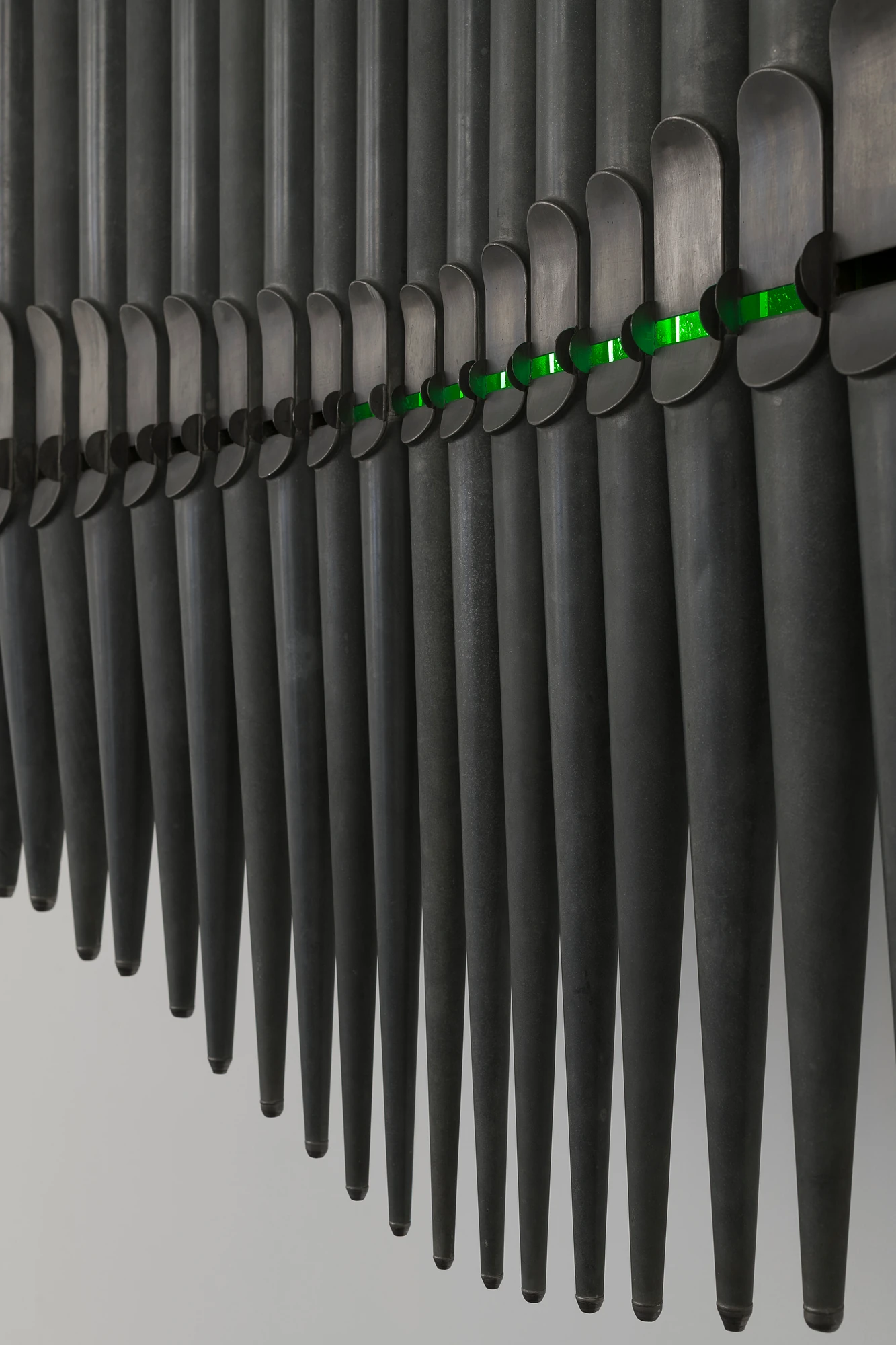 Half-Life of Grace by Jeremy Shaw, photographed by Stefan Korte — Detail of Half-Life of Grace (1958), the glowing green uranium glass showing through the mouths of the organ pipes.