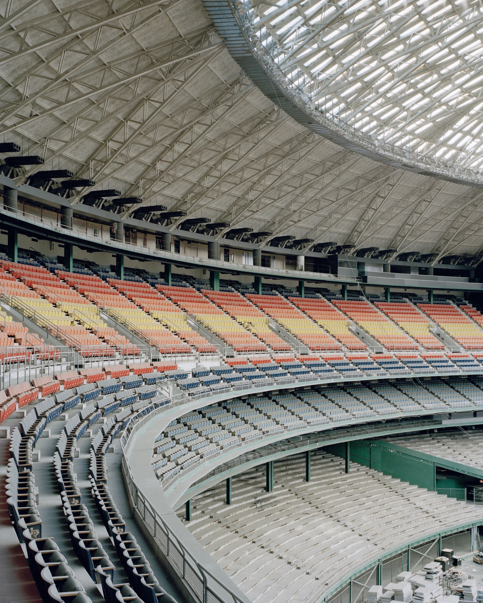 Houston, Untitled by Rory Gardiner, photographed by Rory Gardiner — Untitled: empty tiered seating inside a domed stadium.