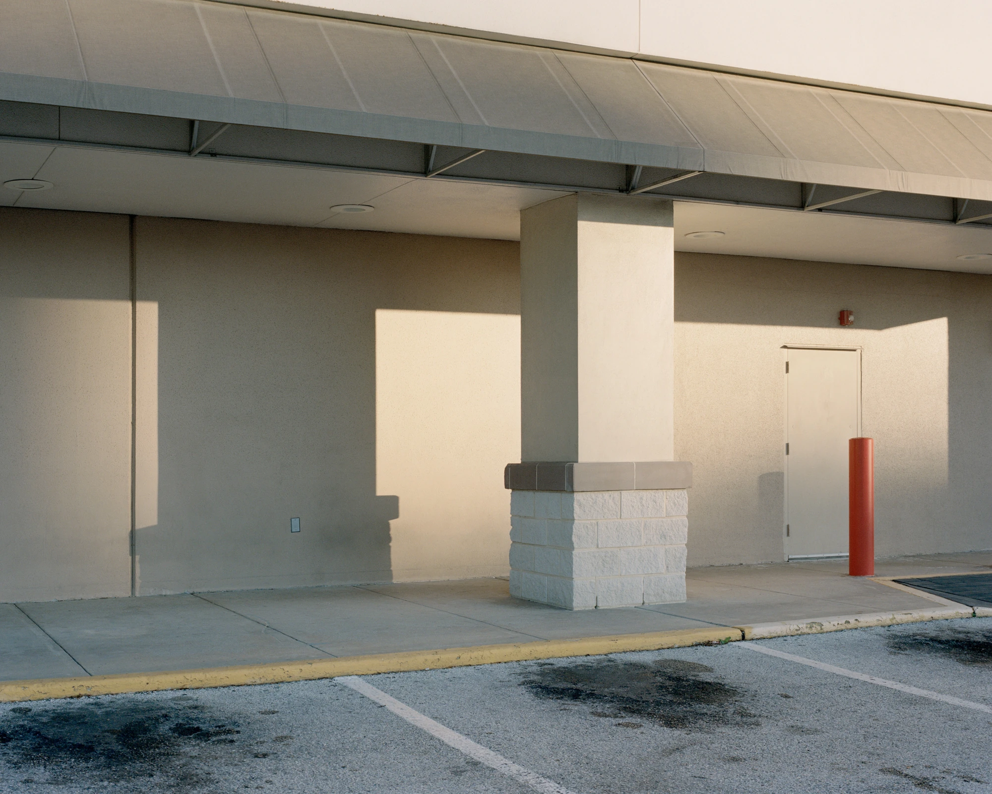 Houston, Untitled by Rory Gardiner, photographed by Rory Gardiner — 29.691110, -95.413818: late-afternoon light casts sharp rectangles across the nondescript wall of a commercial building.