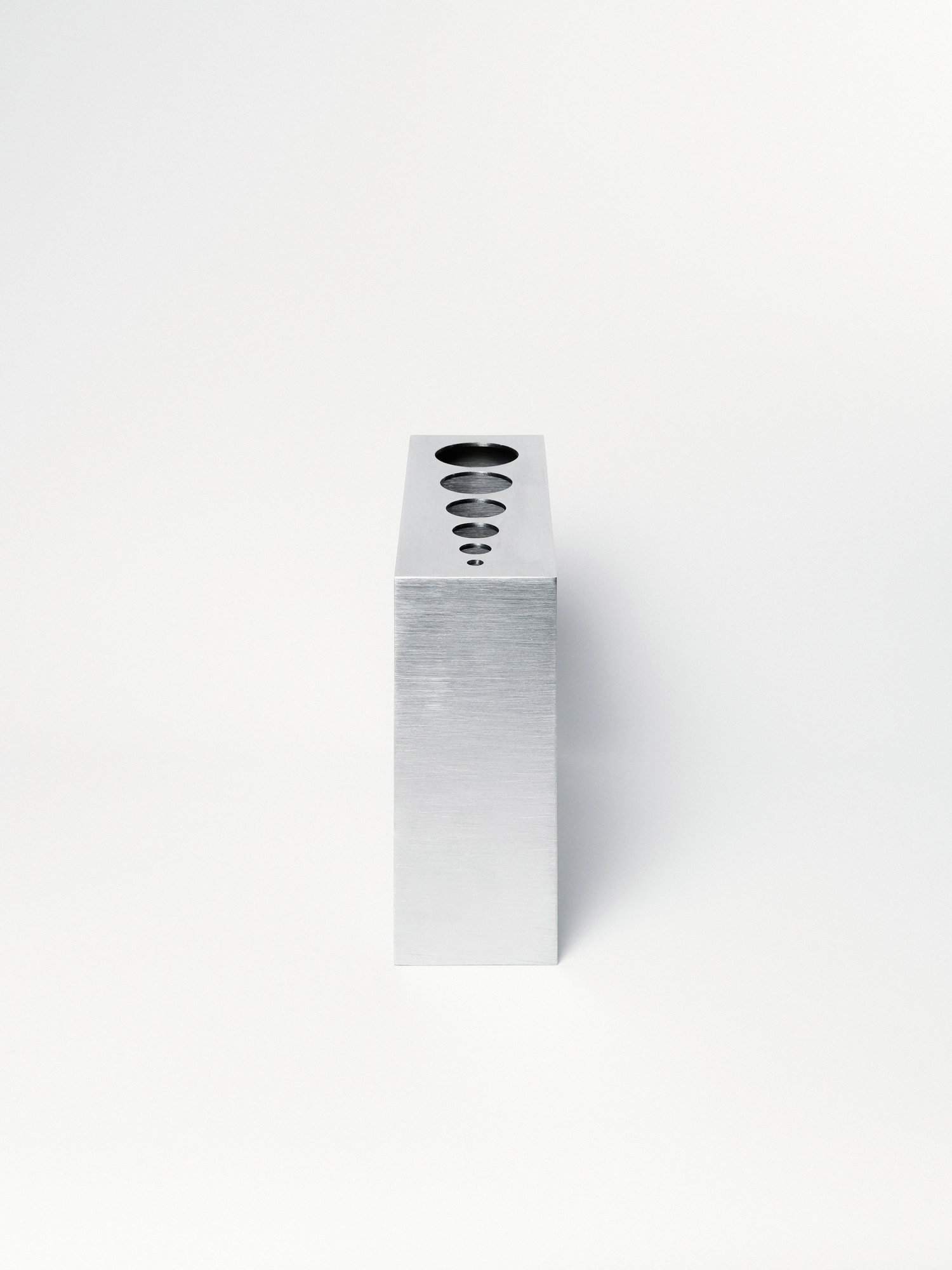 Apropos VASE-21 by Non-Objective, photographed by Elena Gavrilenko — VASE-21 shown end-on, the tall narrow stainless steel block with its openings just visible along the top edge