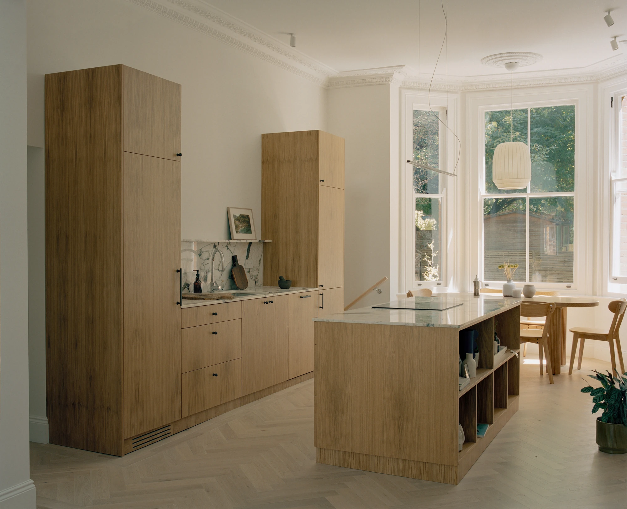 Hampstead House by Twelve Forty One, photographed by Willem Pab — The kitchen in full, floor-to-ceiling oak cabinetry and an island with open shelving.