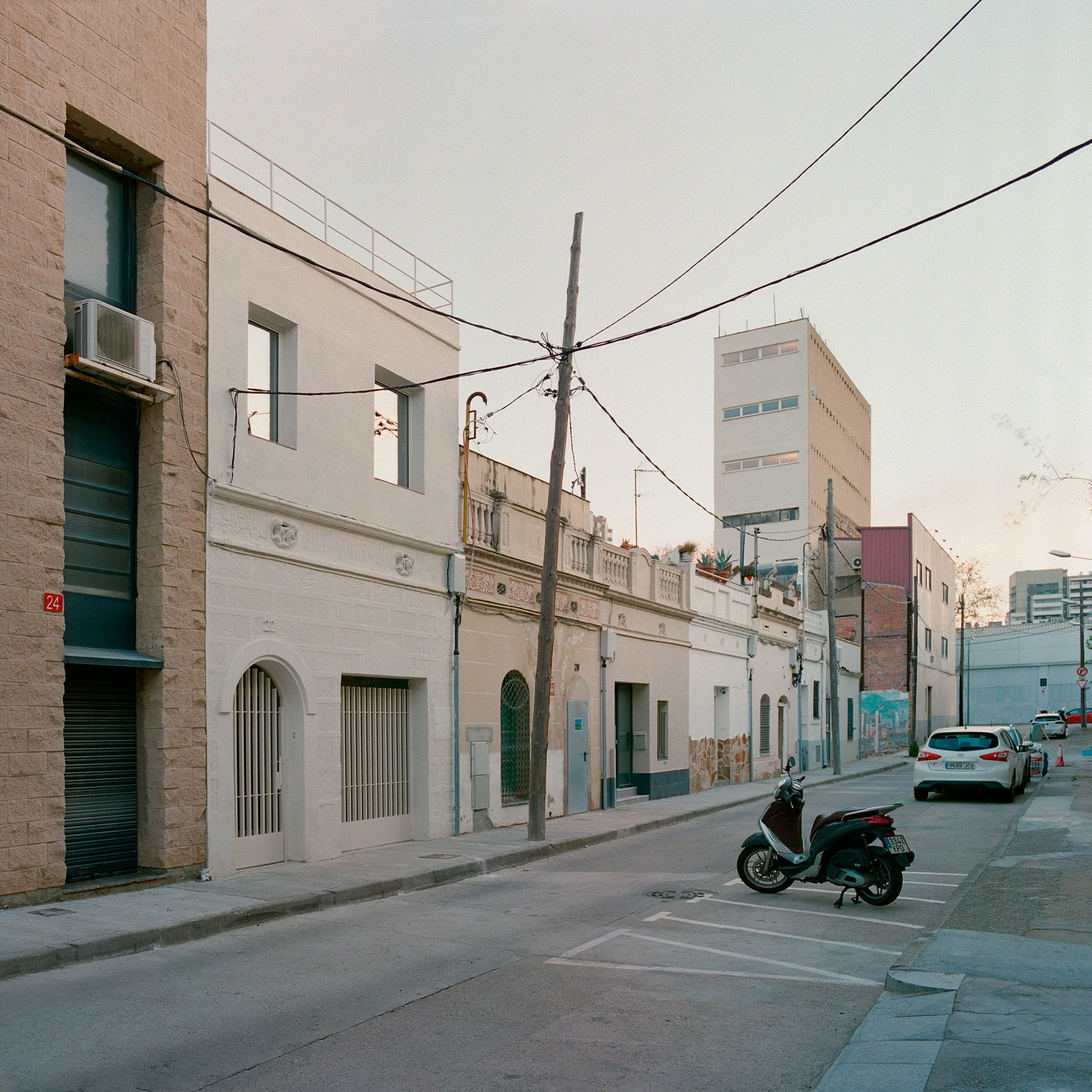 Villa V by Andrea Arriola Fiol and Adrián Mellado Muñoz, photographed by Del Rio Bani — The semi-detached house on its Poblenou street, its plain facade set among older neighbours
