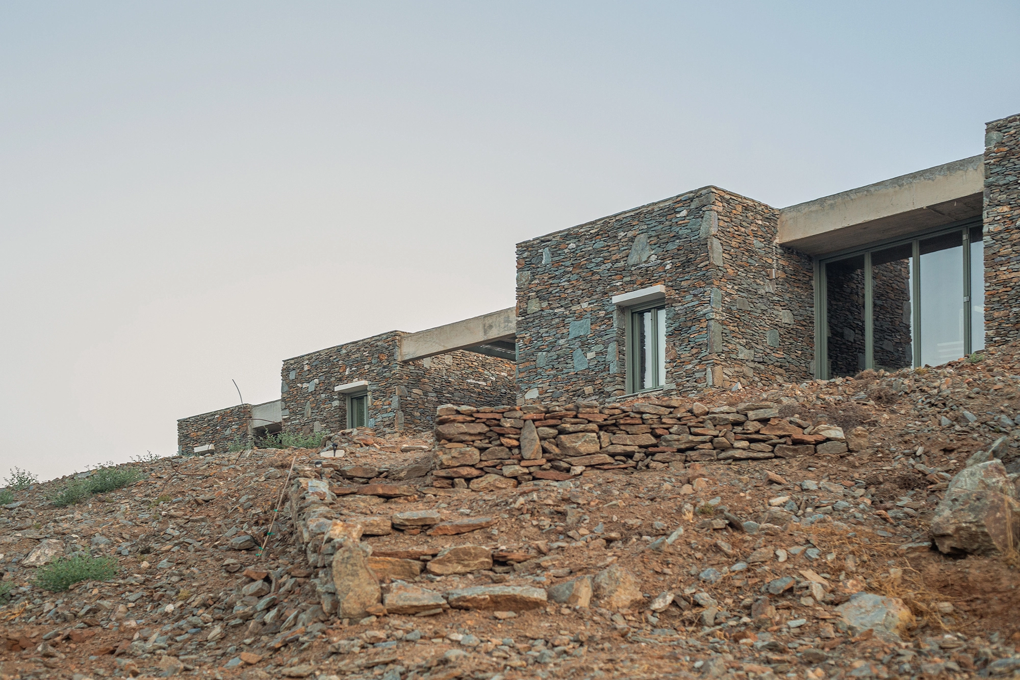House Thermia by RAUM, photographed by Benoit Chailleux — The house from the slope, with a glazed opening between two volumes at Thermia.