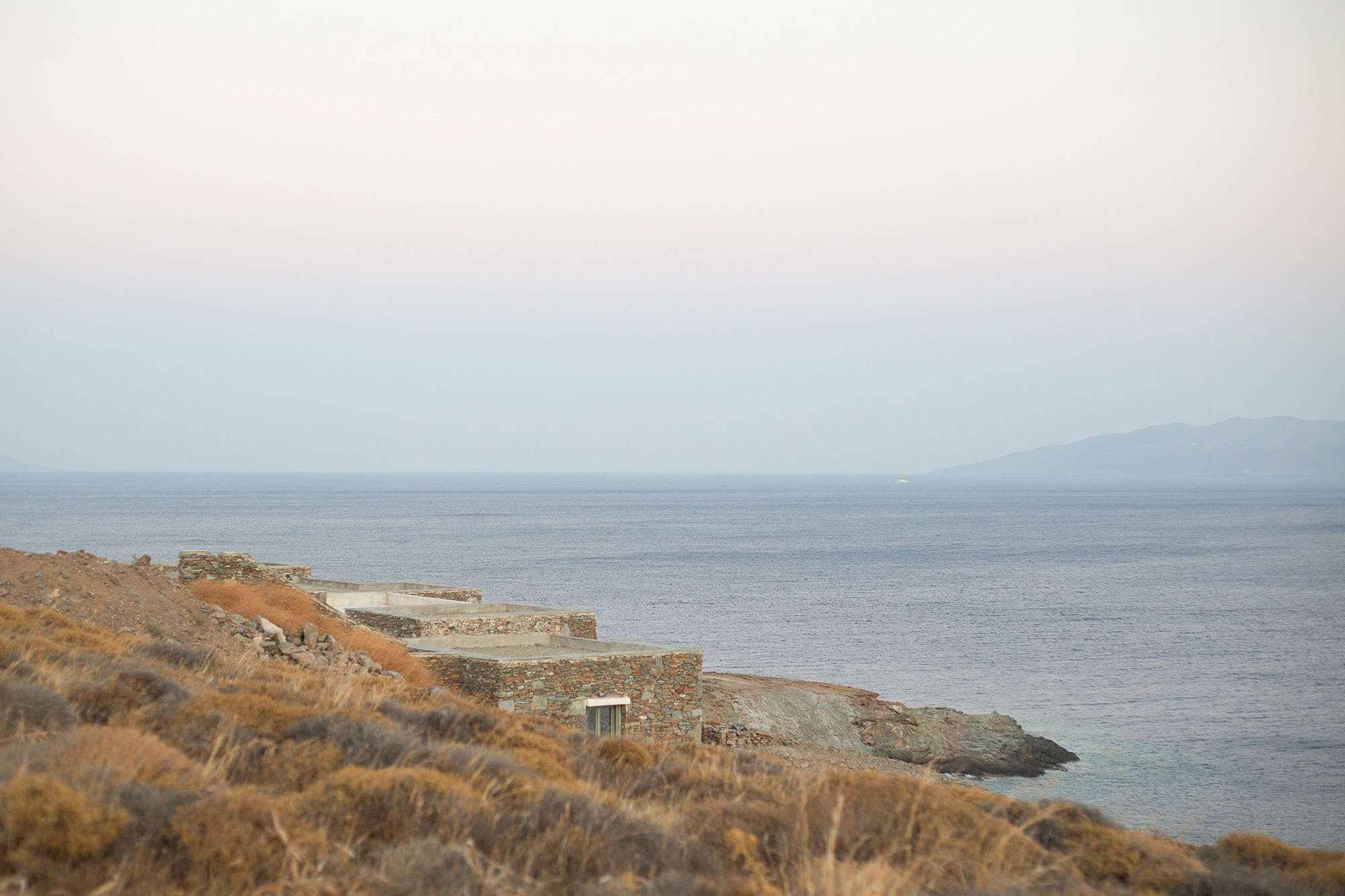 House Thermia by RAUM, photographed by Benoit Chailleux — The terraces of the house reaching toward the sea at Thermia.