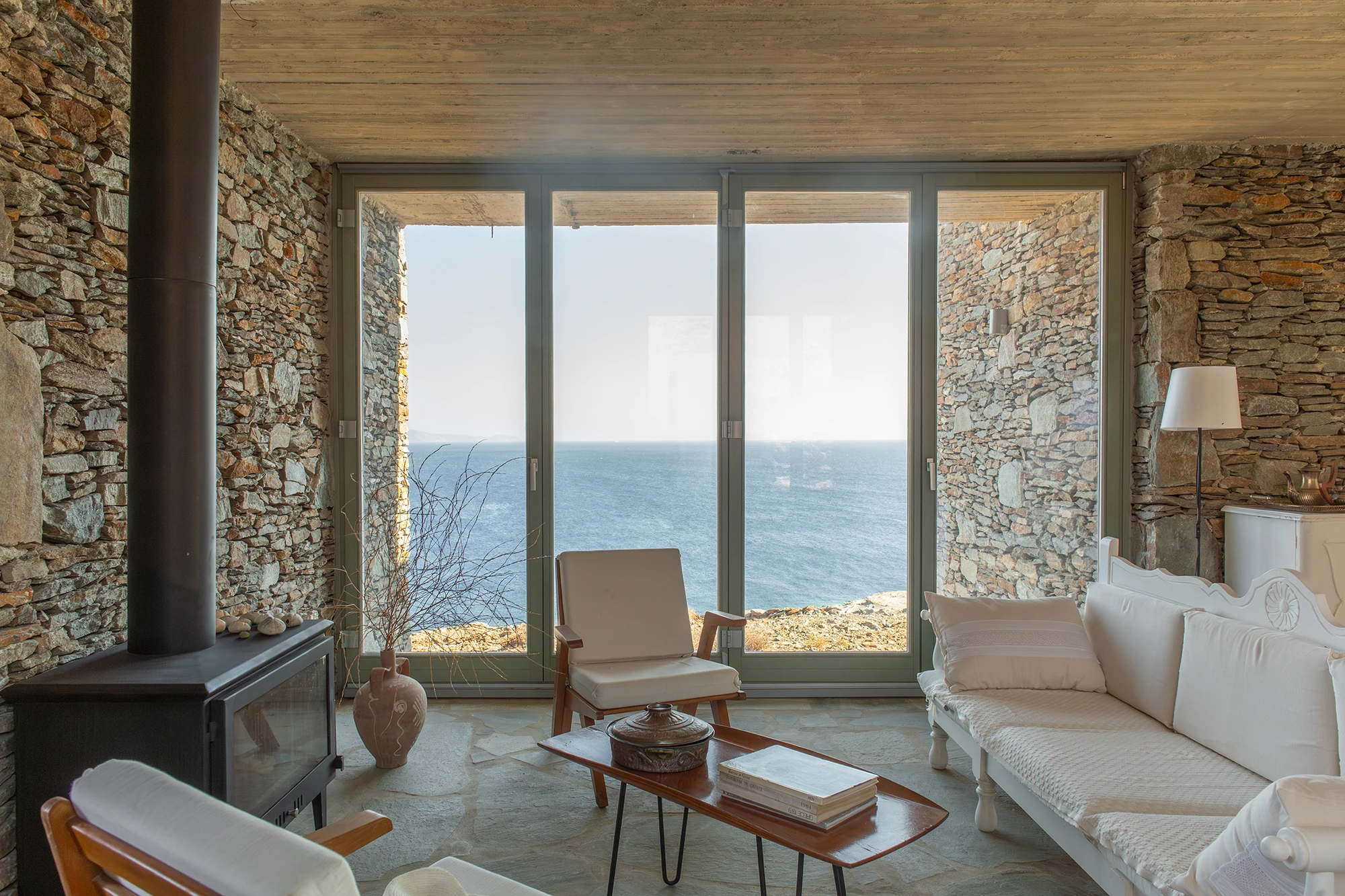 House Thermia by RAUM, photographed by Benoit Chailleux — A living room facing the sea through full-height glazing at Thermia.
