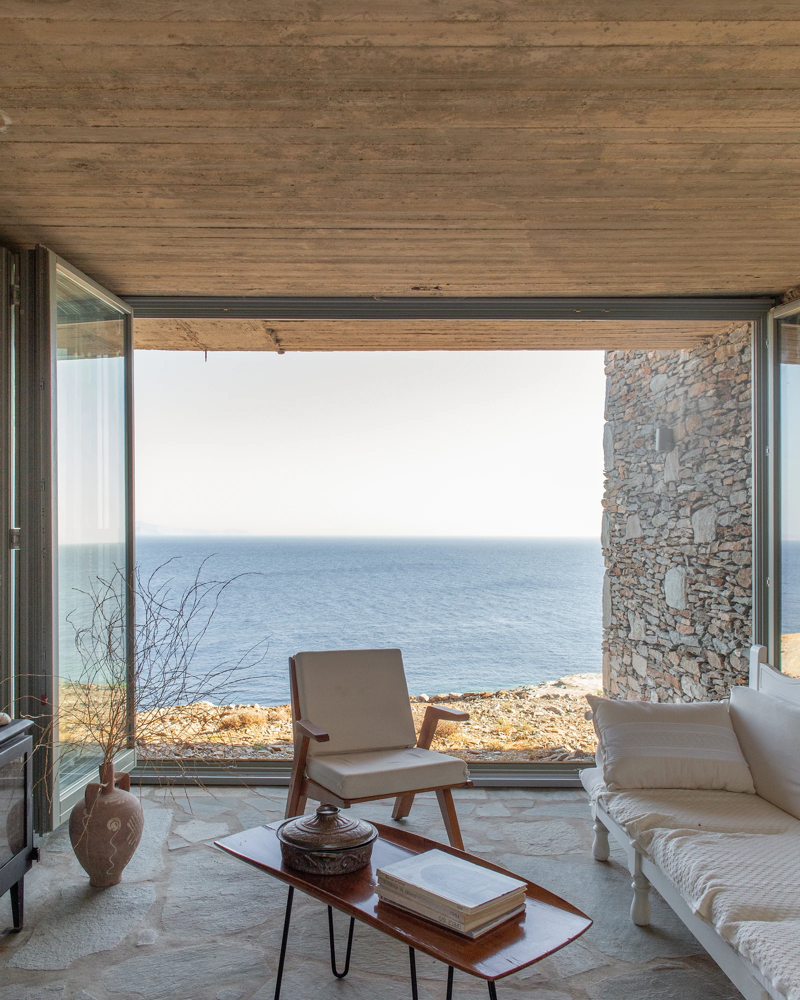 House Thermia by RAUM, photographed by Benoit Chailleux — An interior framing the sea and horizon through the glazing at Thermia.