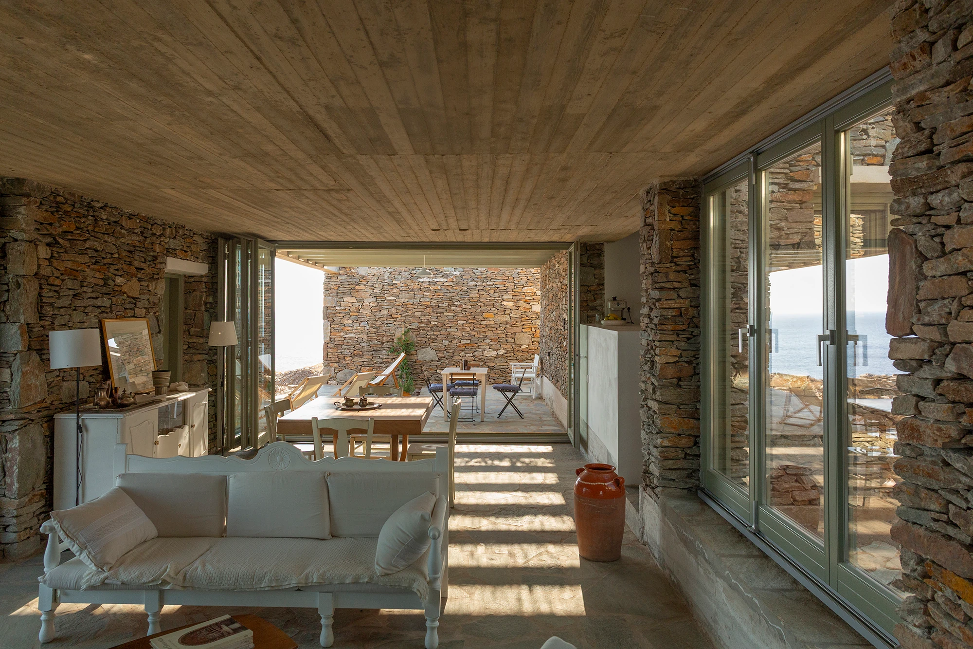 House Thermia by RAUM, photographed by Benoit Chailleux — A living room looking across to the terrace at Thermia.