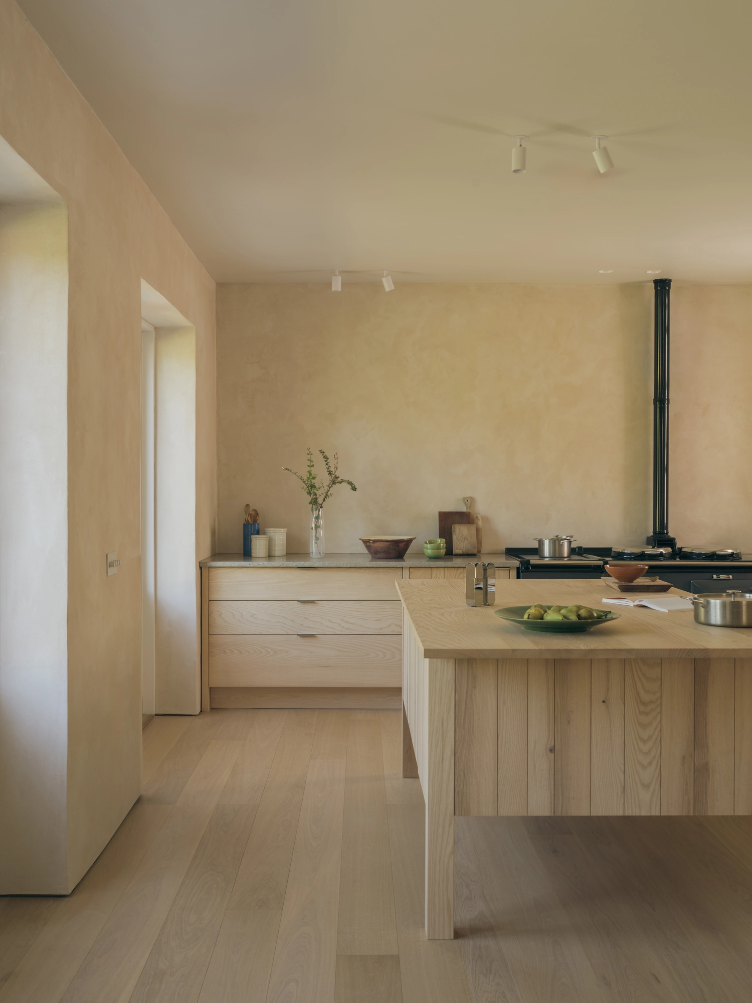 Cairngorm Cottage by Architecture Office, photographed by Richard Gaston — Scottish ash drawers and the central island in the kitchen, set against clay-plaster walls.