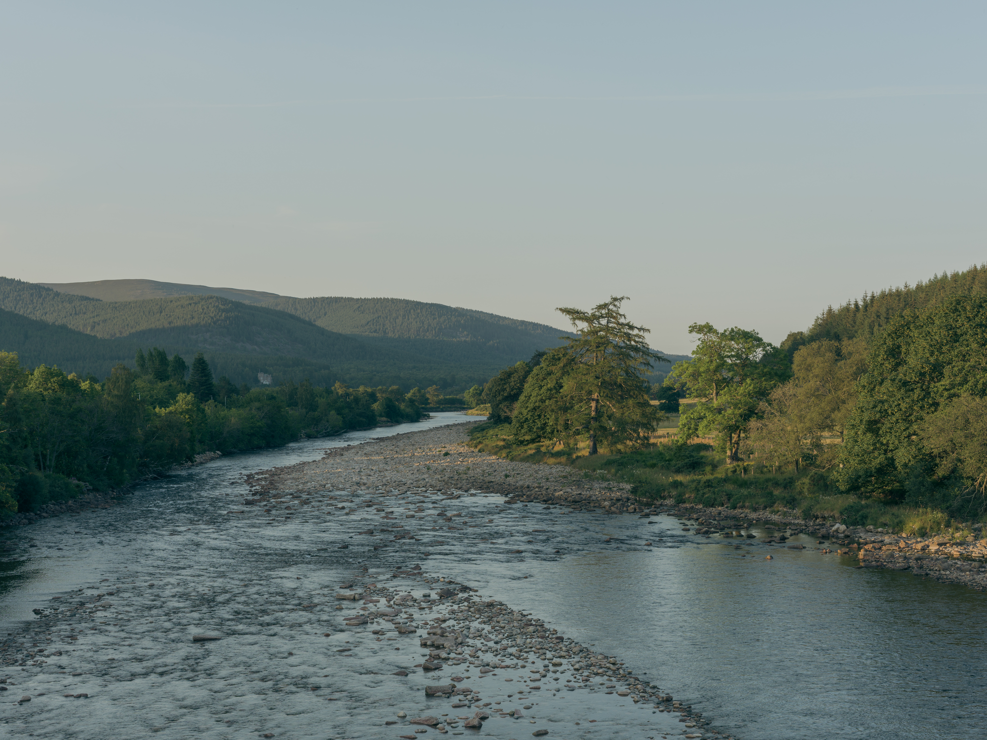Cairngorm Cottage by Architecture Office, photographed by Richard Gaston — The river valley and wooded hills near the village, the setting the cottage sits within.