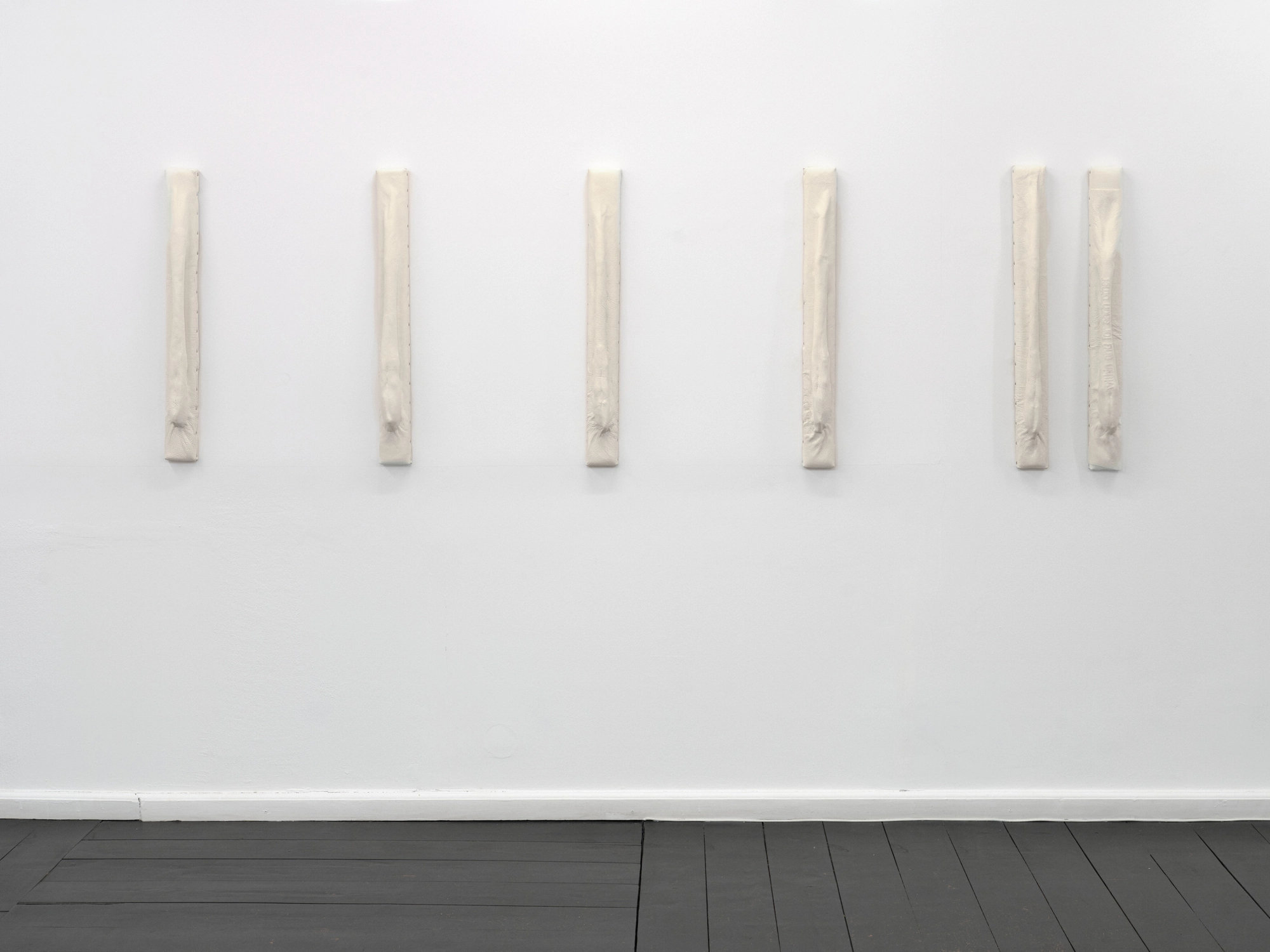 Within and For Each Other by Jan Baszak, photographed by Bartosz Górka — Relief 04 as a row of vertical pieces along the wall.