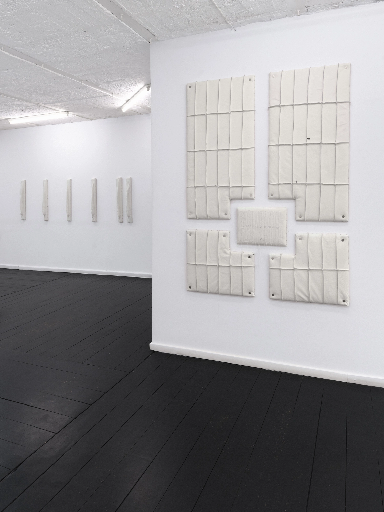 Within and For Each Other by Jan Baszak, photographed by Bartosz Górka — Exhibition view with Relief 03 on the near wall and Relief 04 beyond.