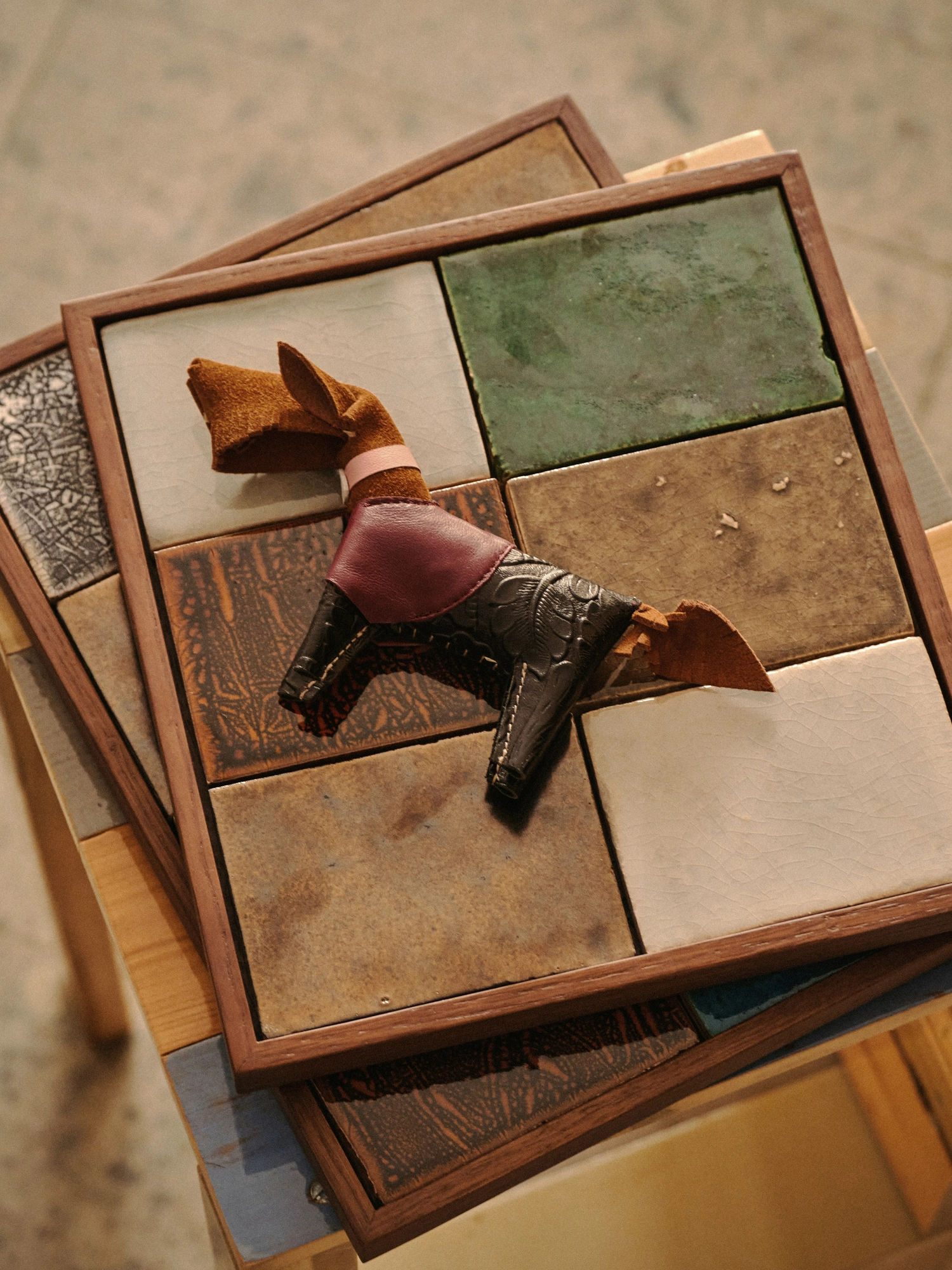 Conceived by Cotemp by ONOAA STUDIO, photographed by Jonathan Leijonhufvud — A small animal-shaped accessory resting on a tray of samples on a table.