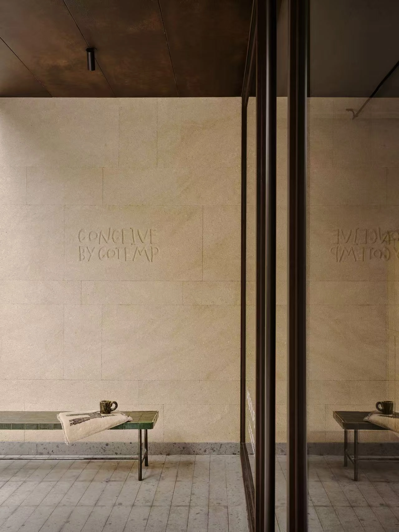 Conceived by Cotemp by ONOAA STUDIO, photographed by Jonathan Leijonhufvud — The shop name on the pale wall at the entrance, a bench below.