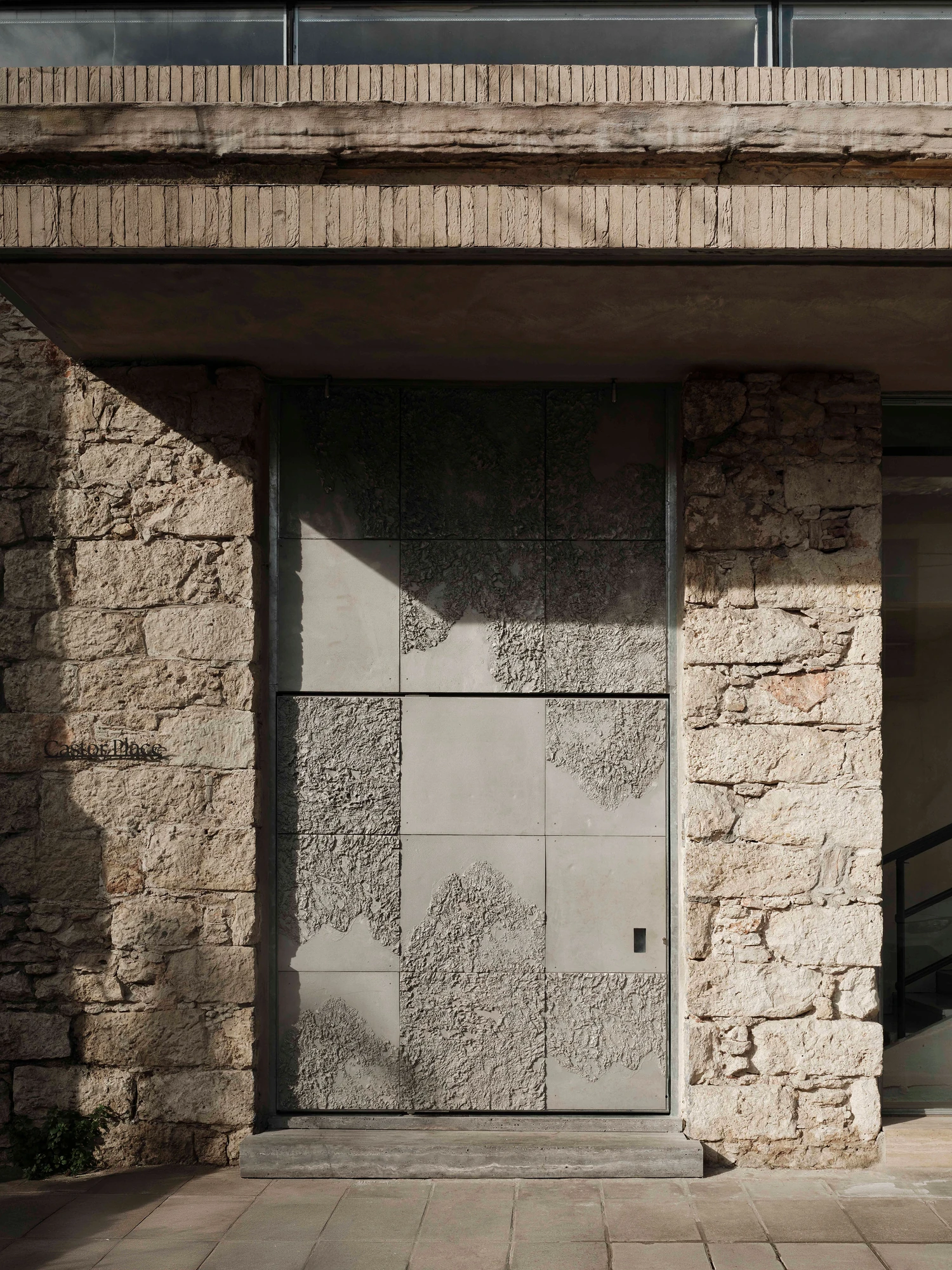 Castor Place by MPNYC, photographed by Yiorgos Kaplanidis — Stefania Strouza's cast aluminium doors set in the stone opening beneath the reclaimed brick canopy