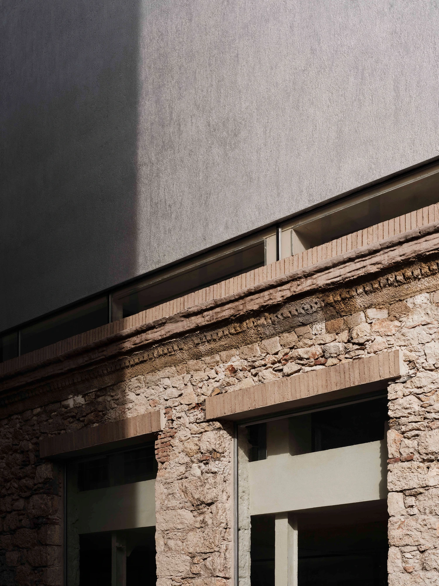 Castor Place by MPNYC, photographed by Yiorgos Kaplanidis — A sunlit corner of the liquid metal volume rising above the old masonry wall and its brick lintels