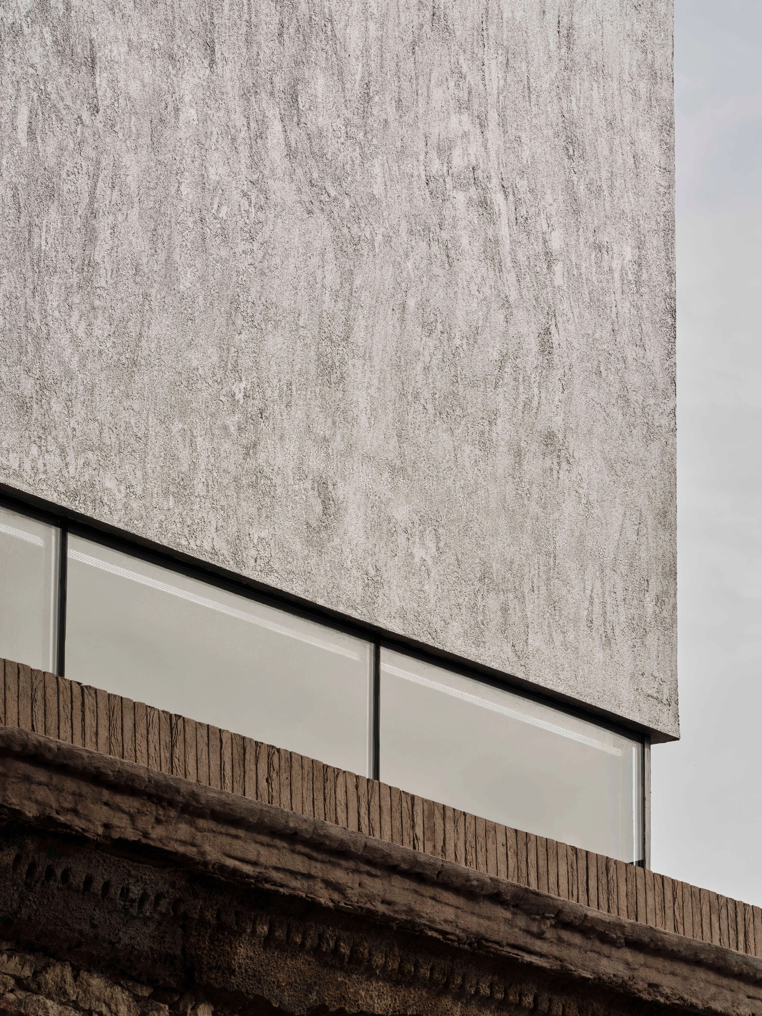 Castor Place by MPNYC, photographed by Yiorgos Kaplanidis — An exterior detail where the liquid metal volume meets a clerestory glazing strip above the old cornice