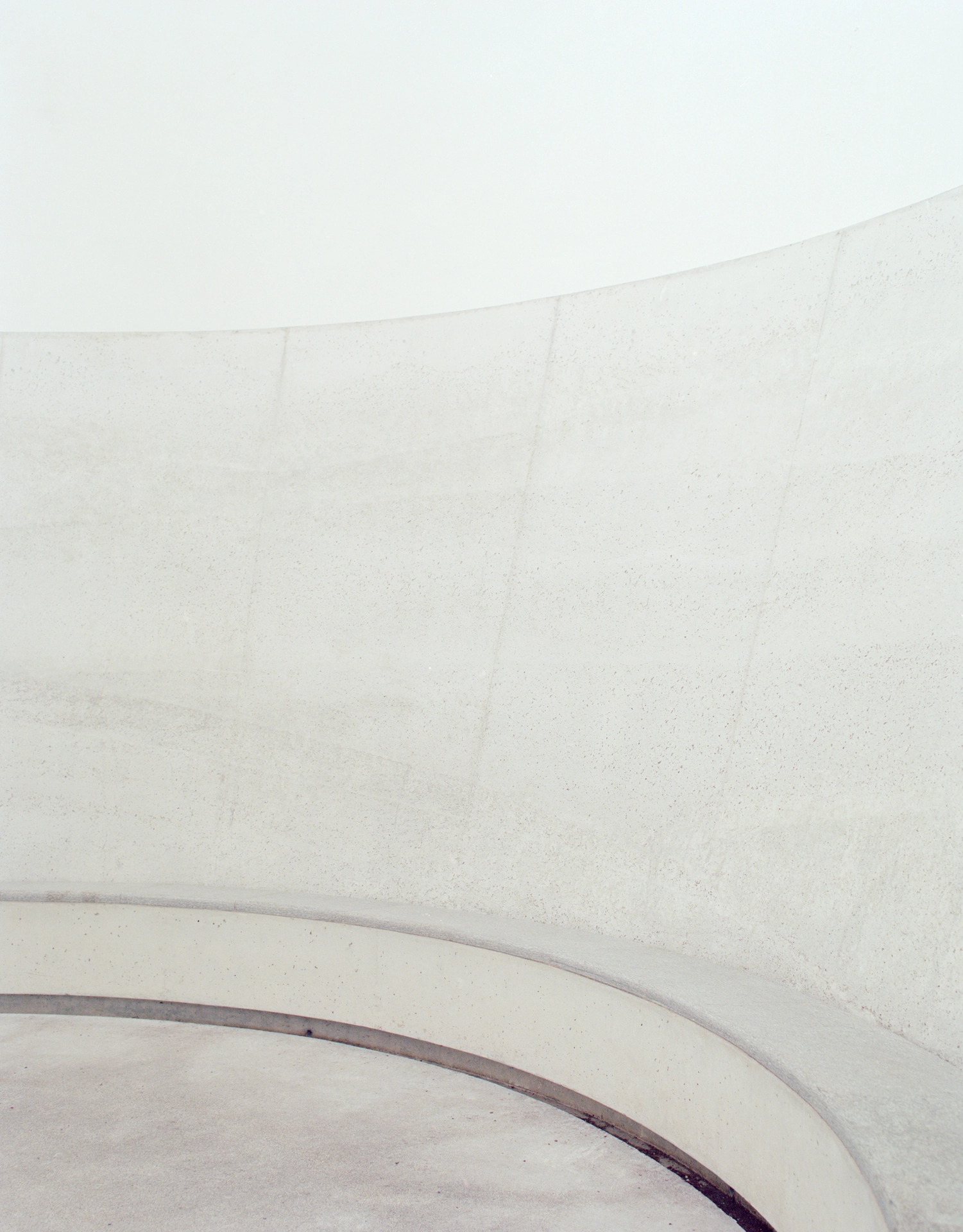 Skyspace Piz Uter by James Turrell, photographed by Marcello Mariana — The curved concrete wall of the interior rises above a continuous ledge that follows the circle of the floor.