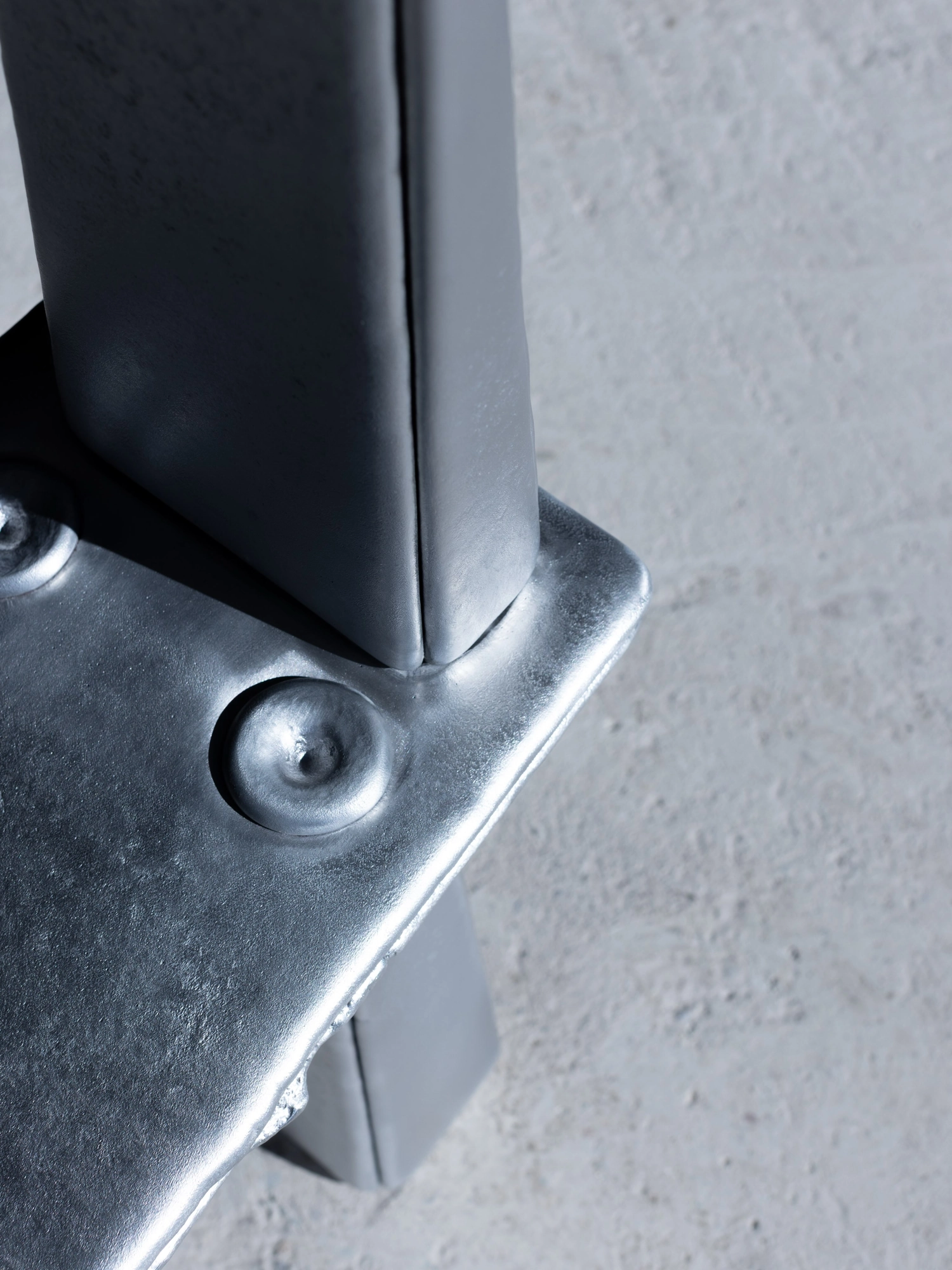 Ingot by Marc Sweeney, photographed by Marc Sweeney — Close detail of the tapered back ingot meeting the seat plate at a rounded pour point, lit in raking sun.