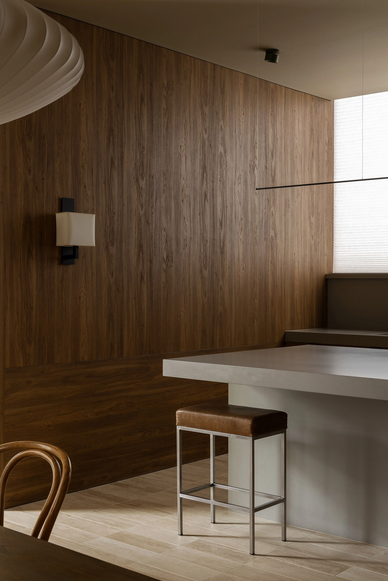 Casa Piva by B.E. Architecture, photographed by Timothy Kaye — The kitchen lined in antique oak, an island bench and a stool.