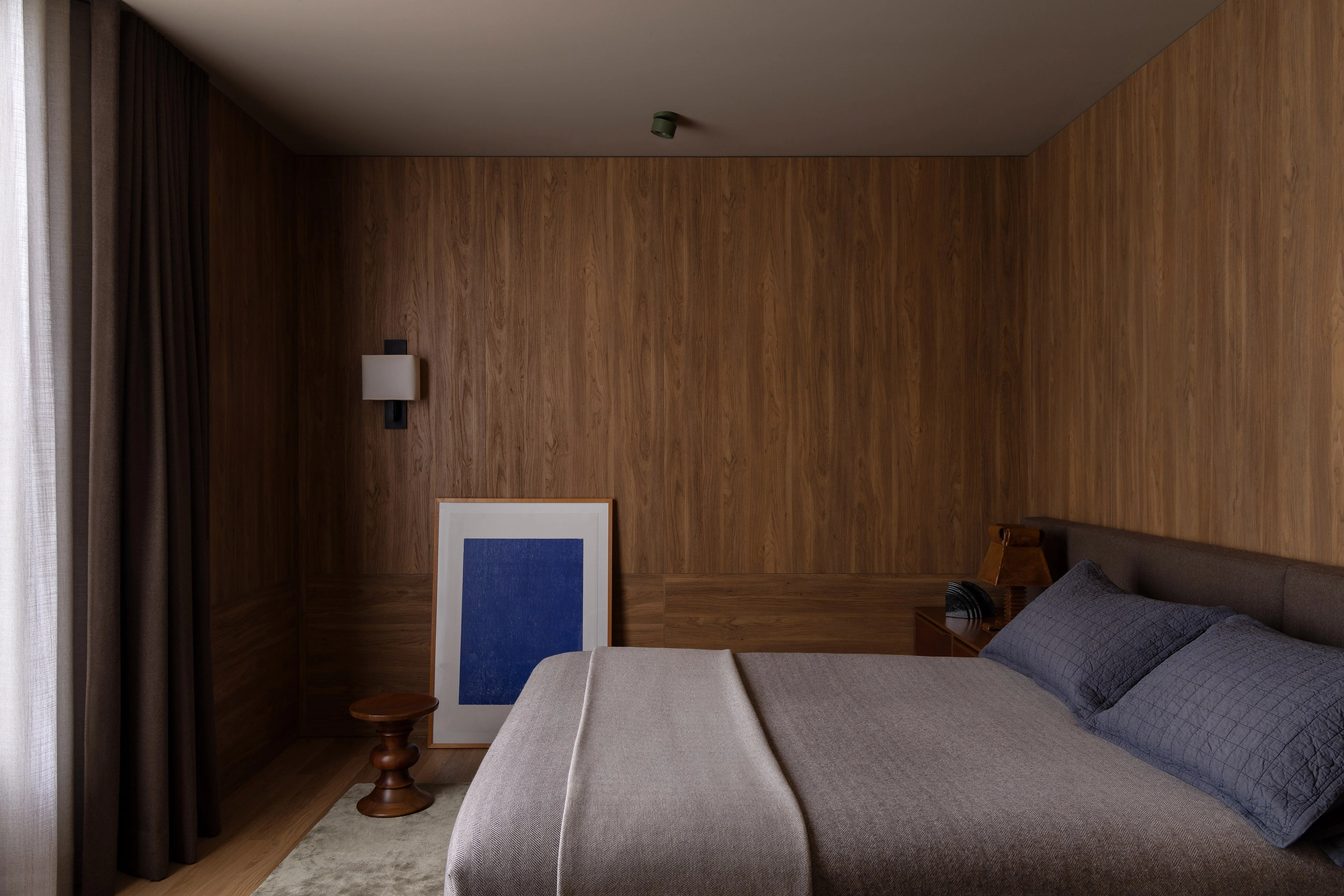 Casa Piva by B.E. Architecture, photographed by Timothy Kaye — The master ensuite bedroom lined in antique oak, with a low bed and soft curtains.