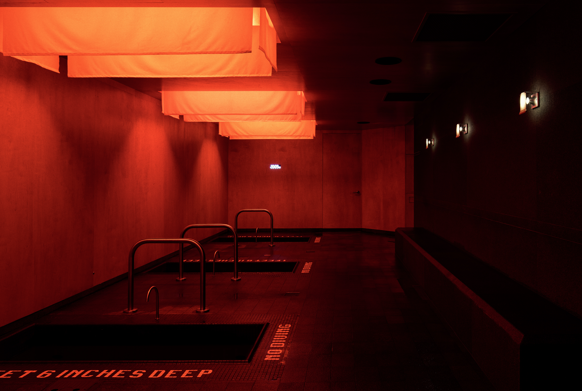 The Altar by MV-LLC — The cold-plunge room with its four basins beneath fabric light suspensions.