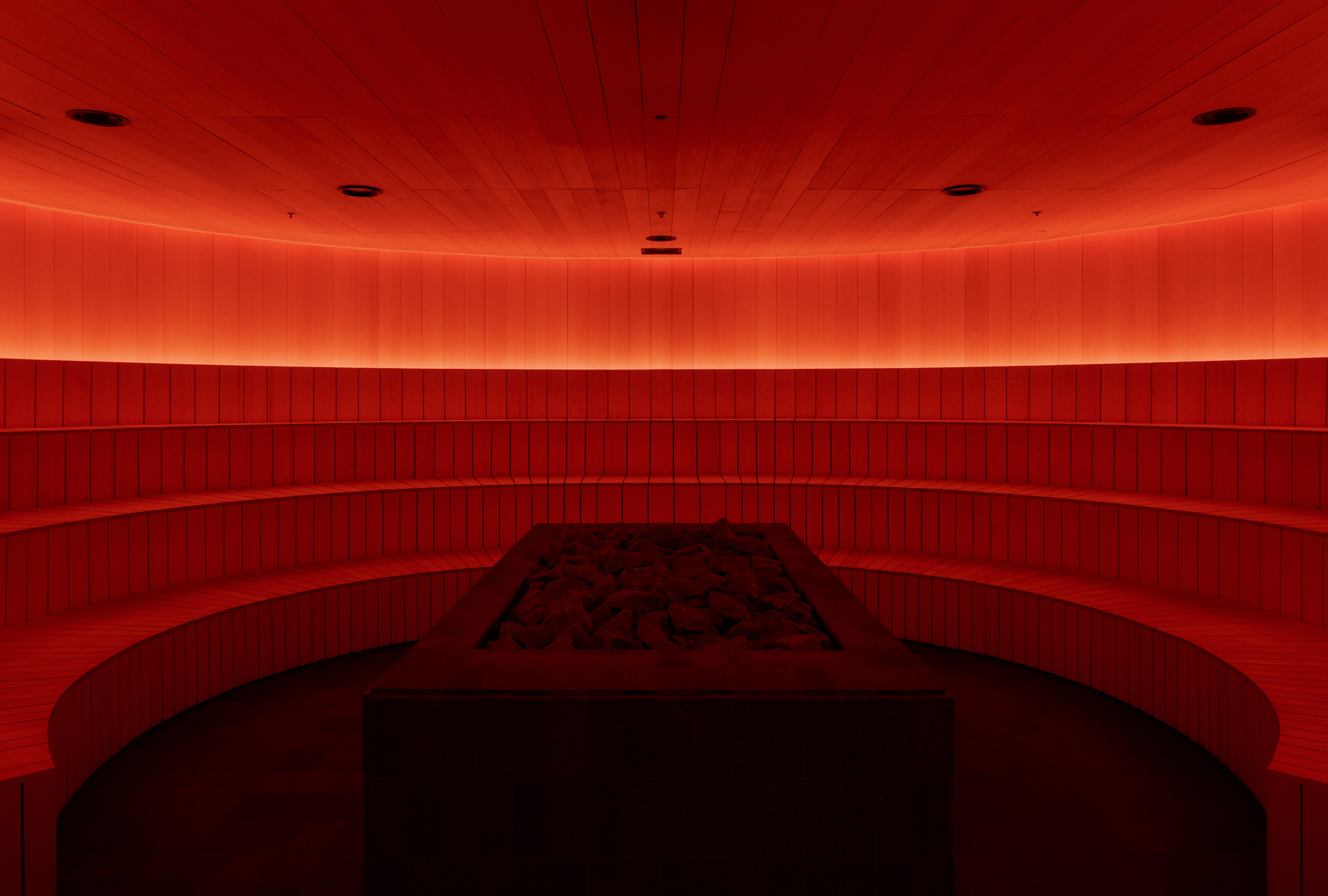 The Altar by MV-LLC — Cedar planks arranged in a radial fashion around the sauna's stone-clad oven.