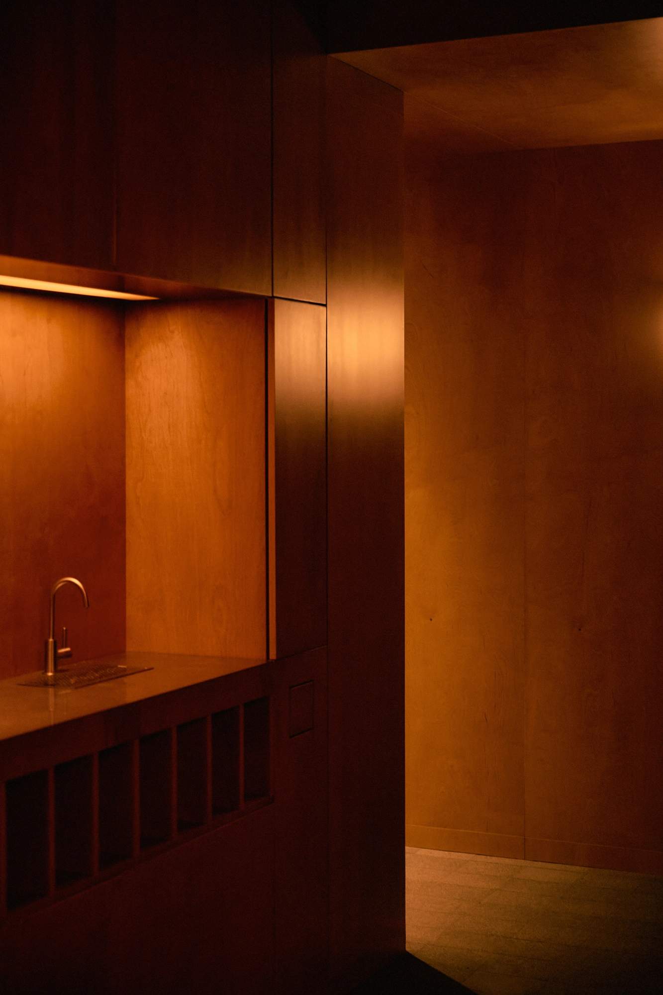 The Altar by MV-LLC — One of the two tea stations within the atrium, a faucet set into a wood-clad niche.