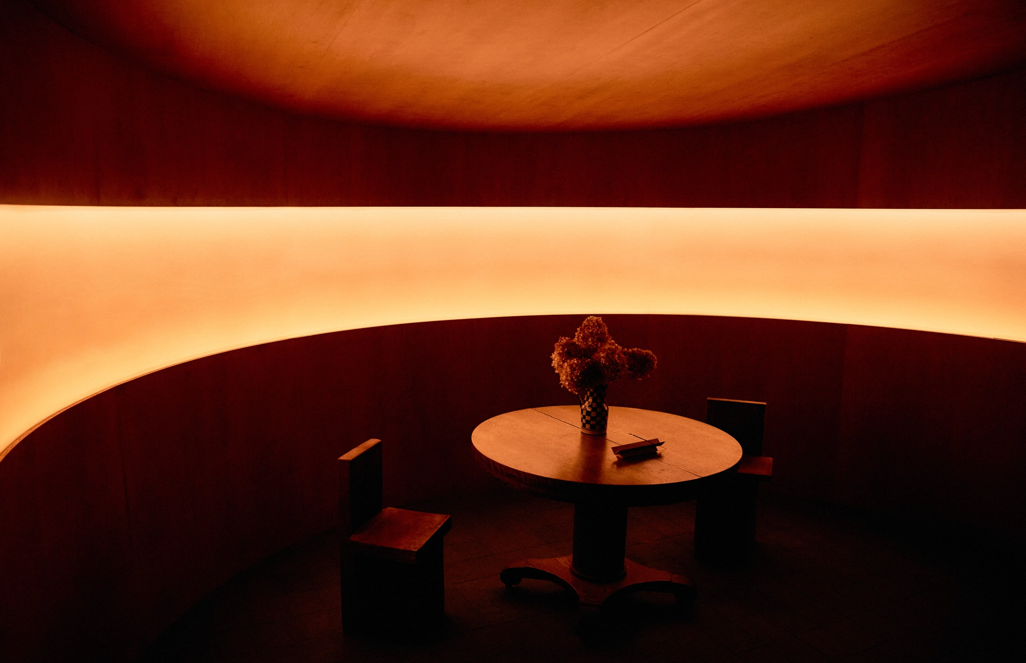 The Altar by MV-LLC — The lower-level vestibule, a curved backlit FRP panel behind a round table and chairs.