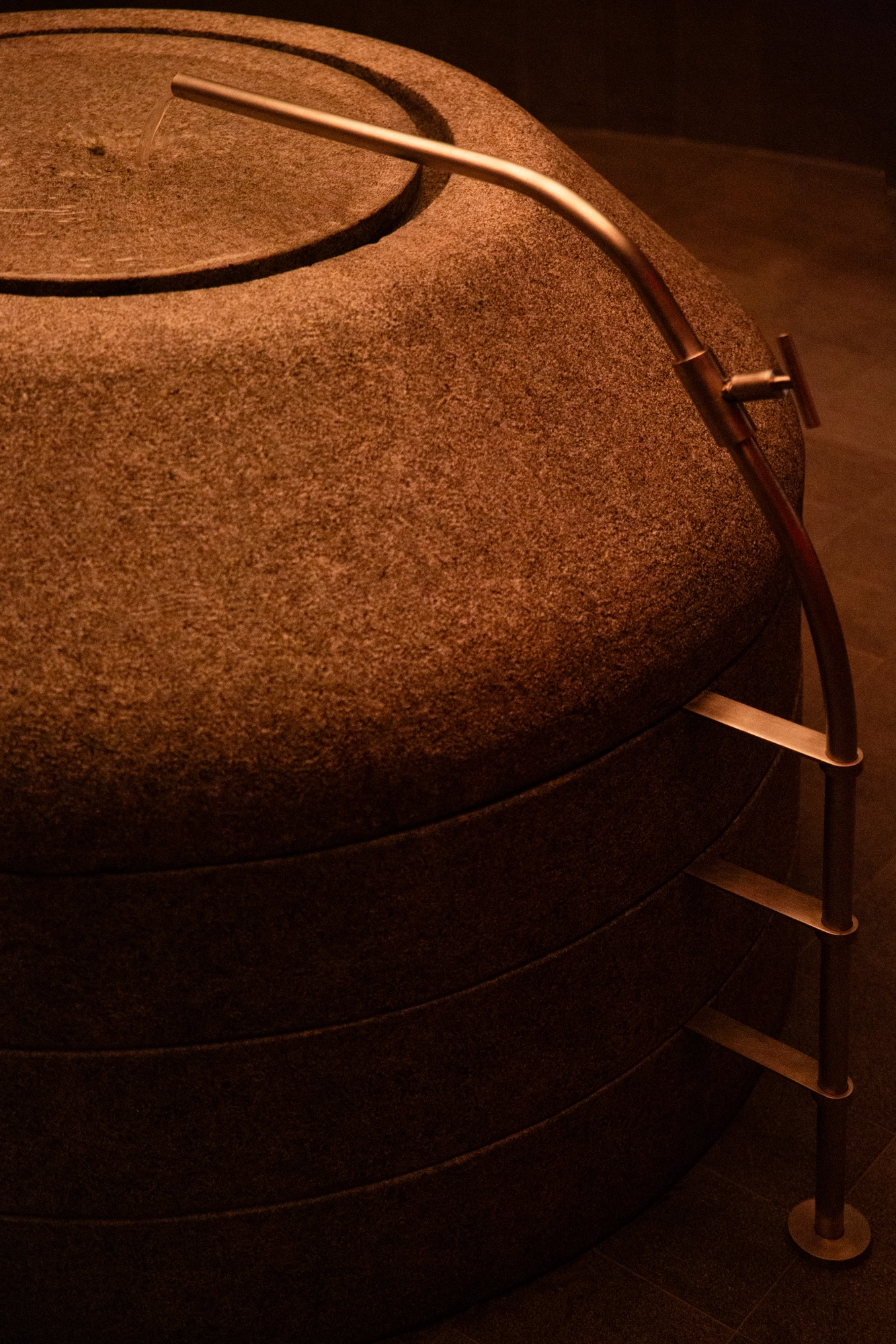 The Altar by MV-LLC — The custom faucet tied back to the stacked stone volumes of the bush-hammered basin.