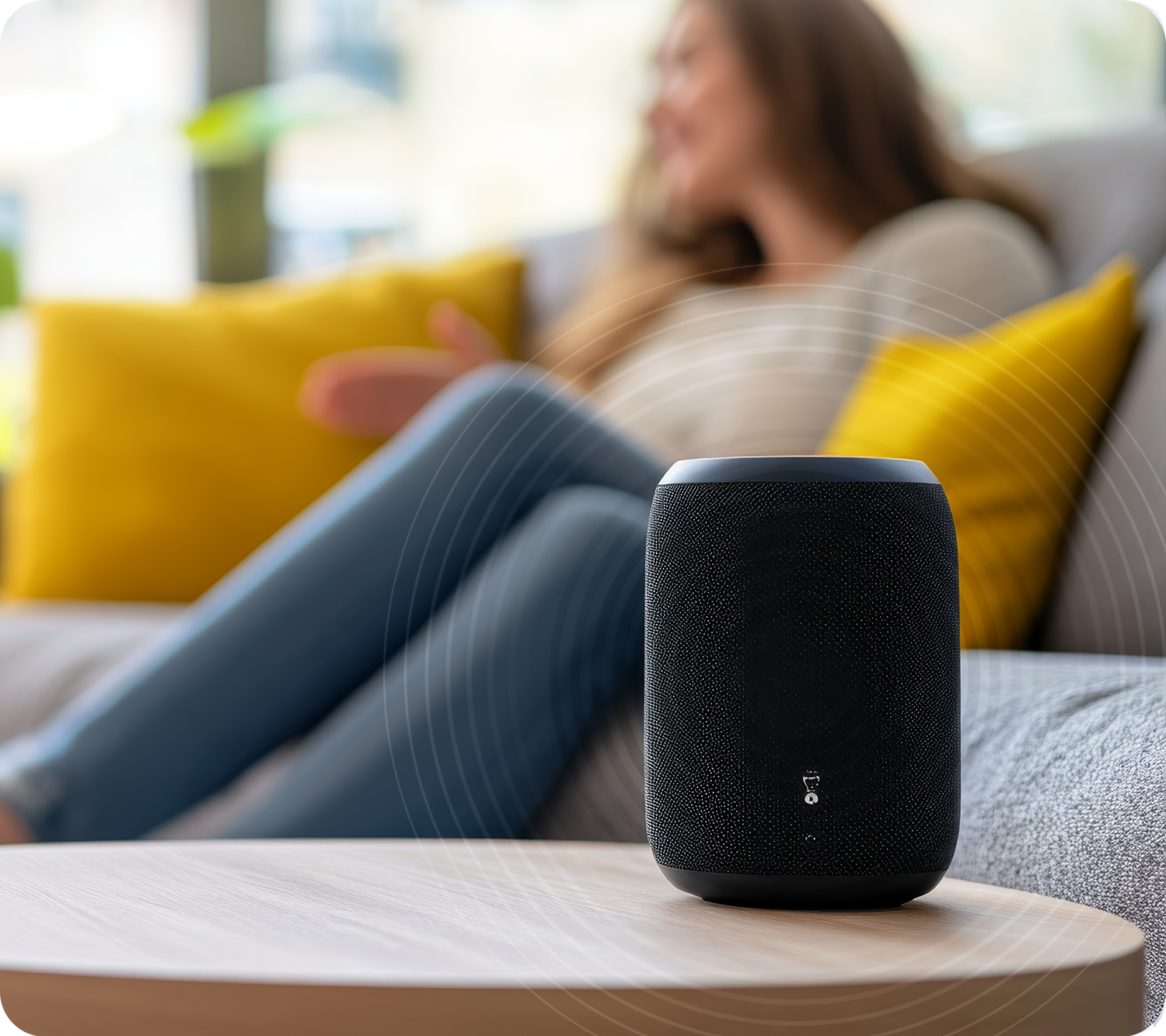 Photo of a woman and a smart speaker on a table. 