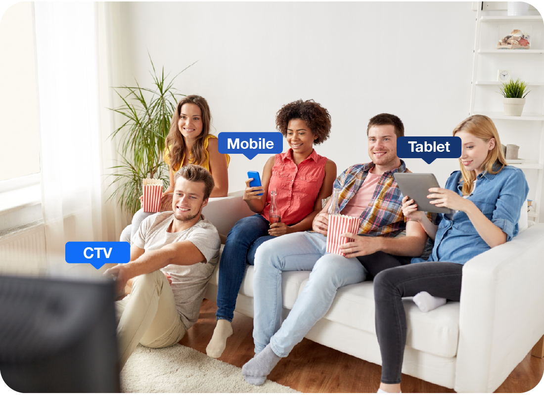 A group of people watching tv and also looking at other content through their phone and tablet. 