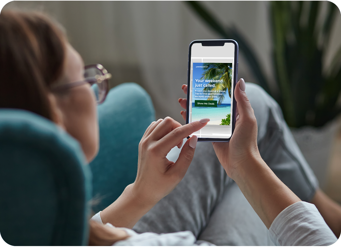 Woman in couch looking at an ad on her phone