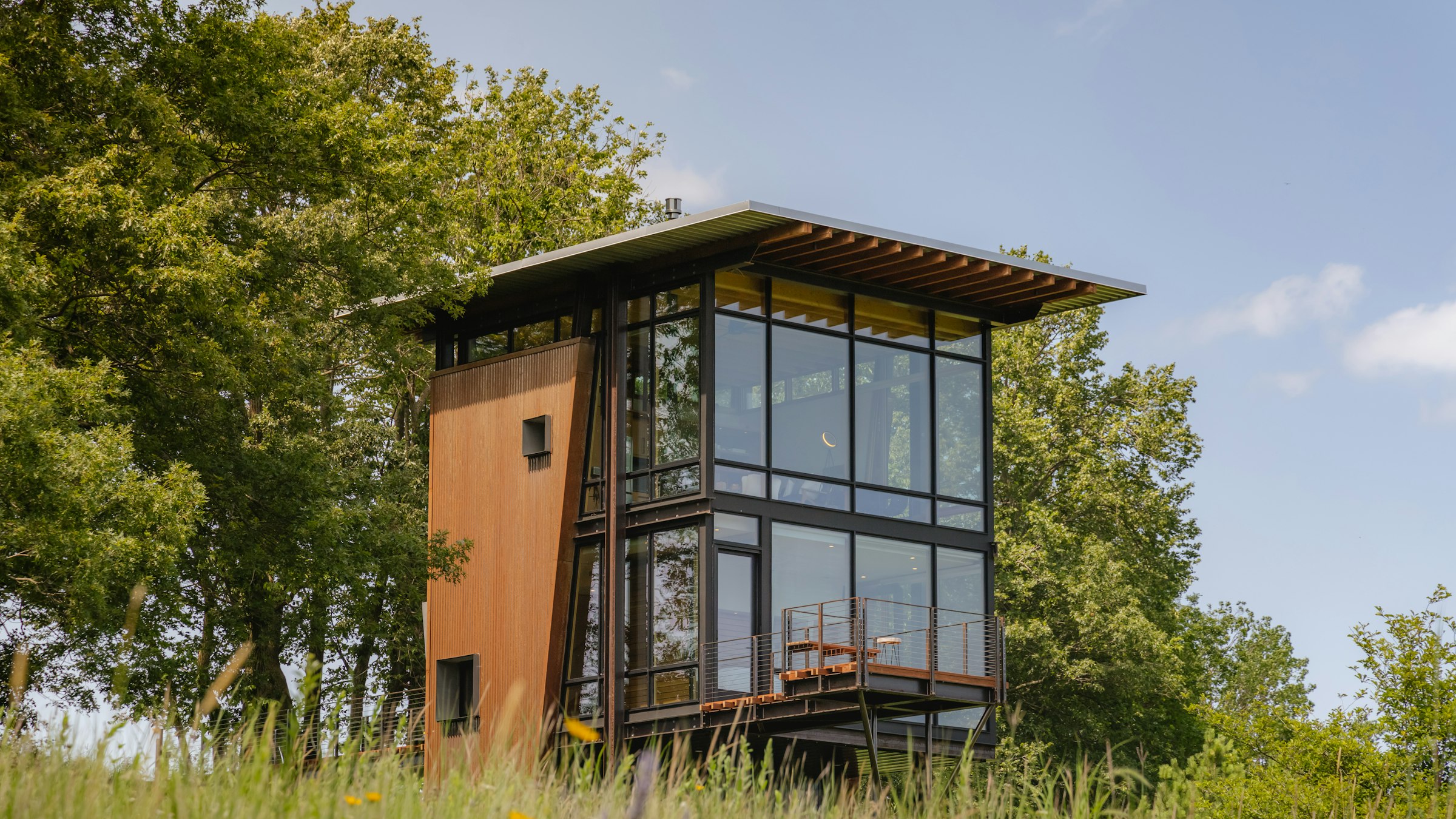A small modern glass-fronted cabin among trees