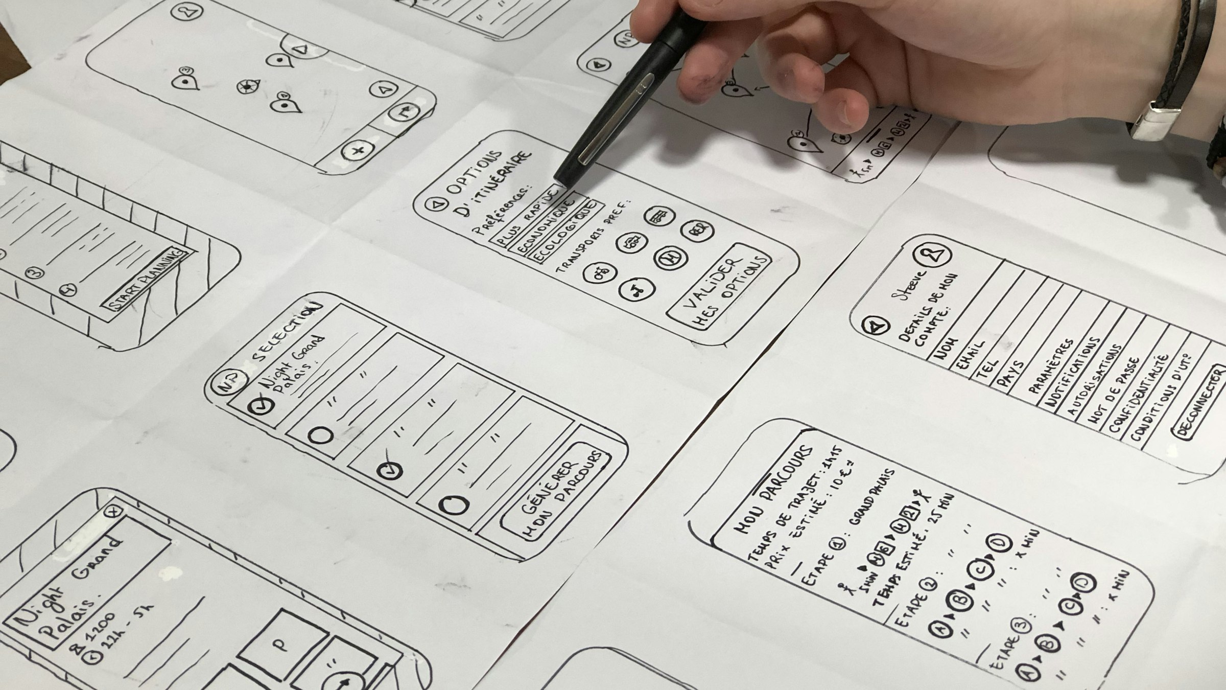 A designer sketching app screens on paper